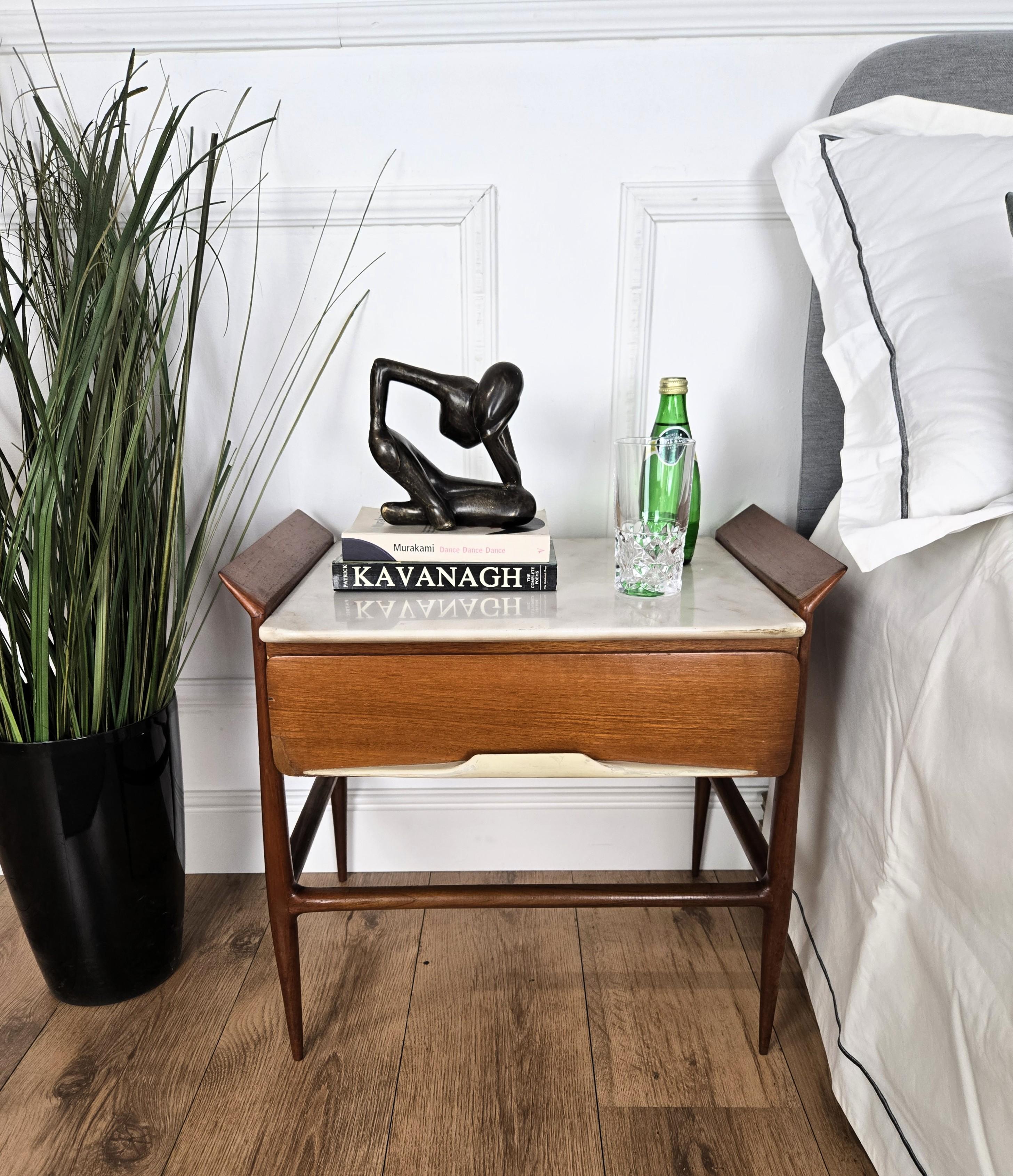 Elegantissima e raffinata coppia di comodini italiani degli anni '50 Mid-Century Modern Neoclassico con dettagli molto sagomati e struttura in legno decorato, cassetti frontali e bellissimo piano in marmo bianco con splendide maniglie. Questi