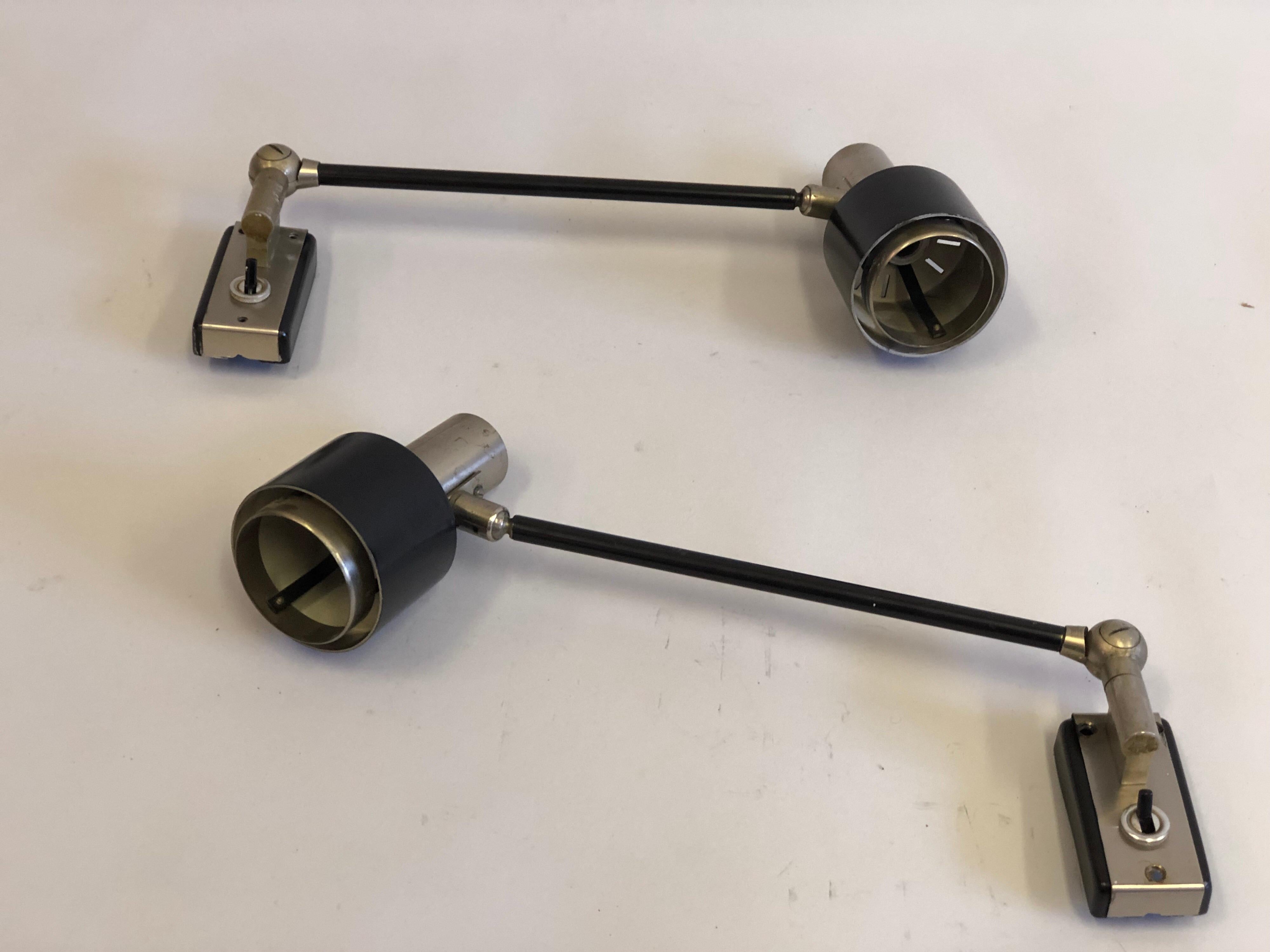 Pair of Italian Mid-Century Modern articulating brushed stainless steel and black enameled steel wall sconces / flush mounts by Stilnovo, Italy, circa 1960.

The pieces are adjustable, articulate fully and are multi-functional and can serve as