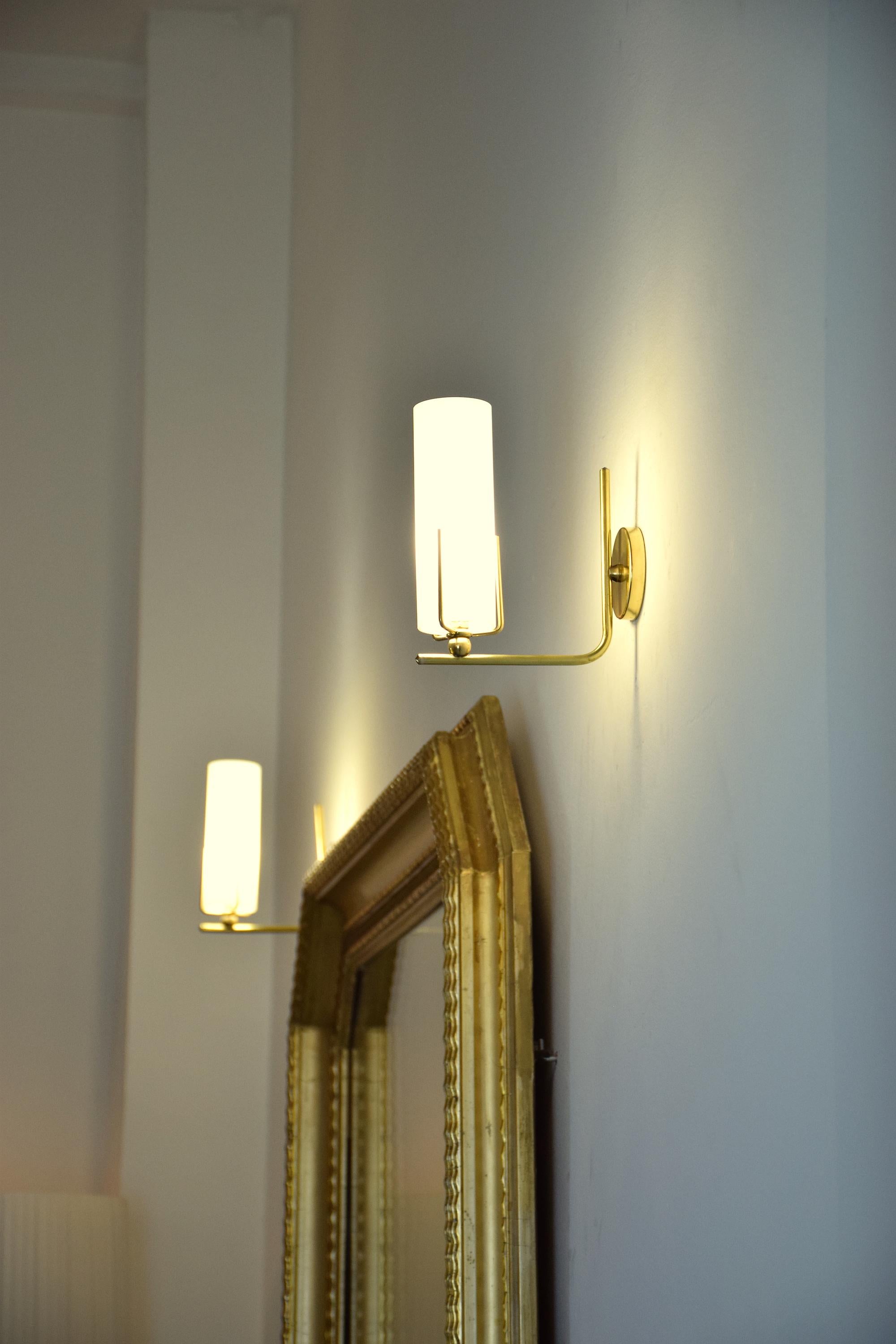 A set of two 20th century sconces designed in brass and opaline glass in a timeless design. 
Italy, circa 1960s. 

All our pieces are fully restored at our atelier and we only offer items that will last another lifetime. There may be light