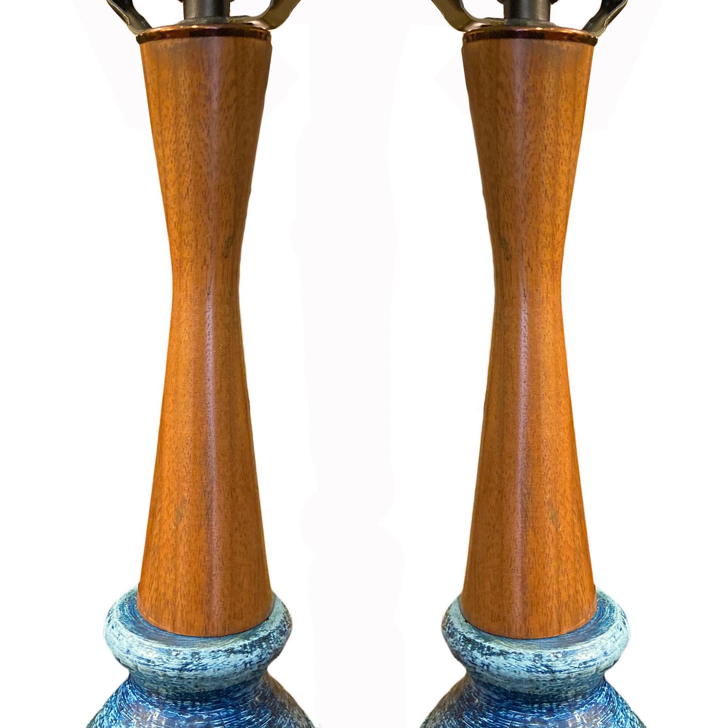 A pair of circa 1950's Italian blue table lamps with wood stems.

Measurements:
Height of body: 22.5