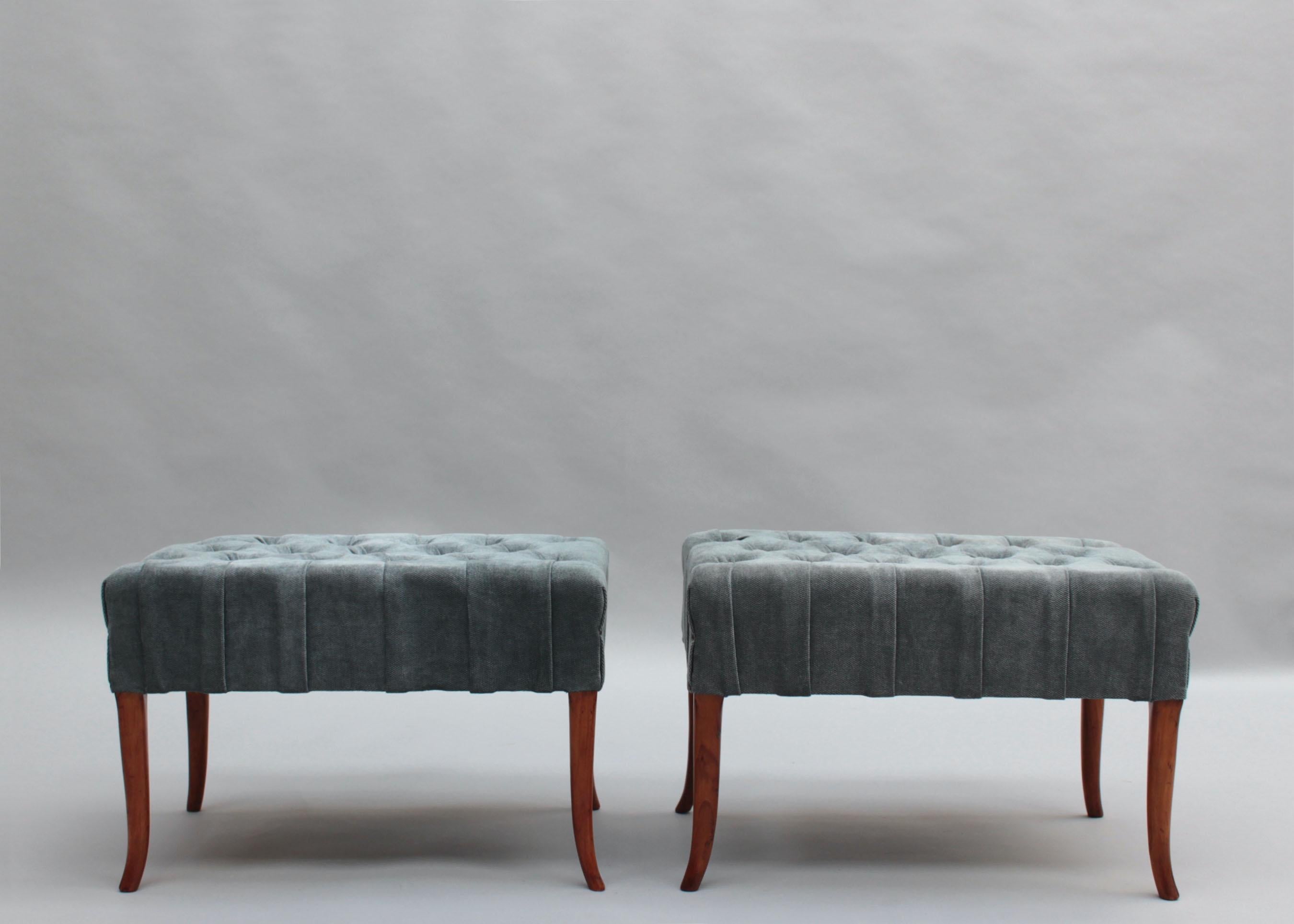 A pair of 1960s Italian buttoned chesterfield benches with wooden legs.
