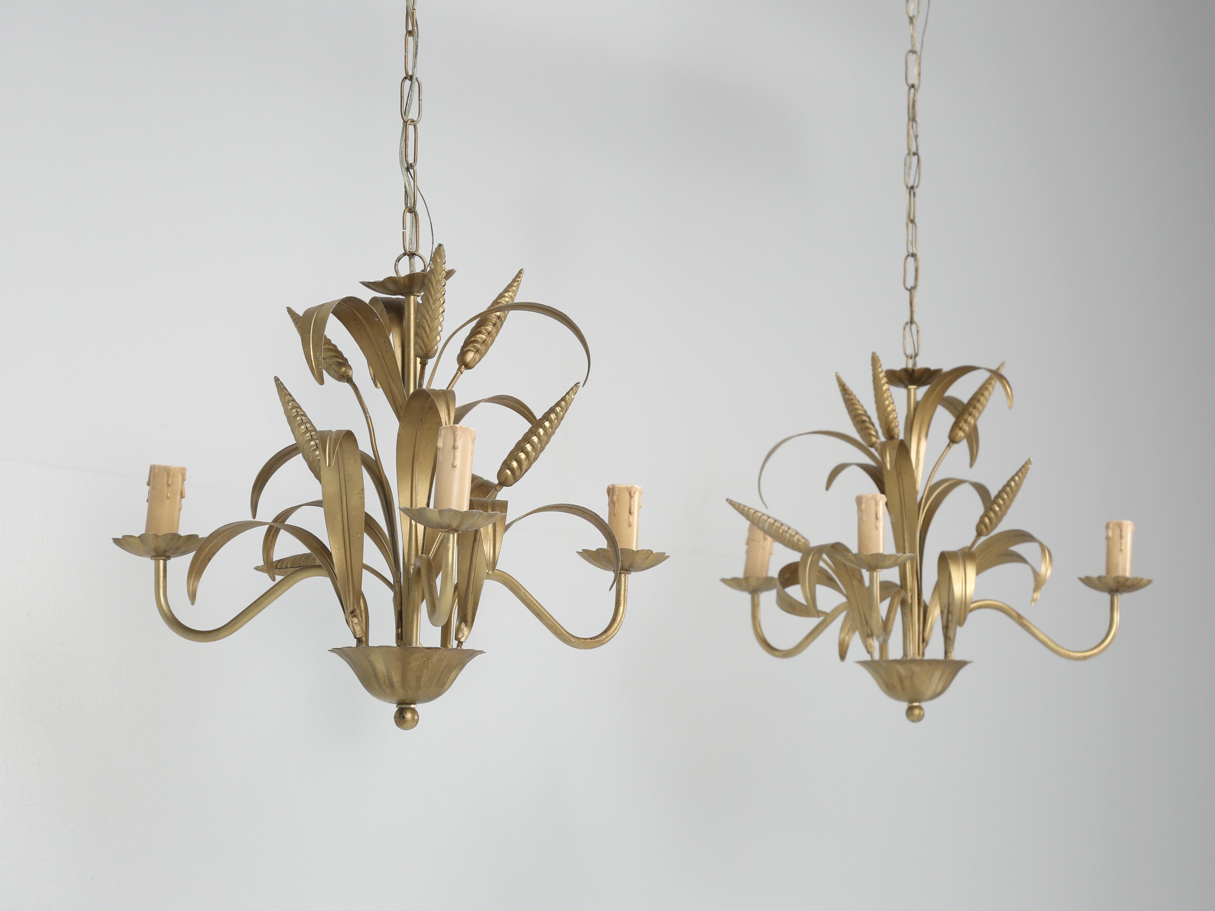 Pair of Hollywood Regency “ Coco Chanel “ style, sheaf of wheat, 4-light gold gilt metal chandeliers made in Italy, circa 1960s. We have a total of four matching gold gilded metal 4-light metal chandeliers in stock and all were removed from the same