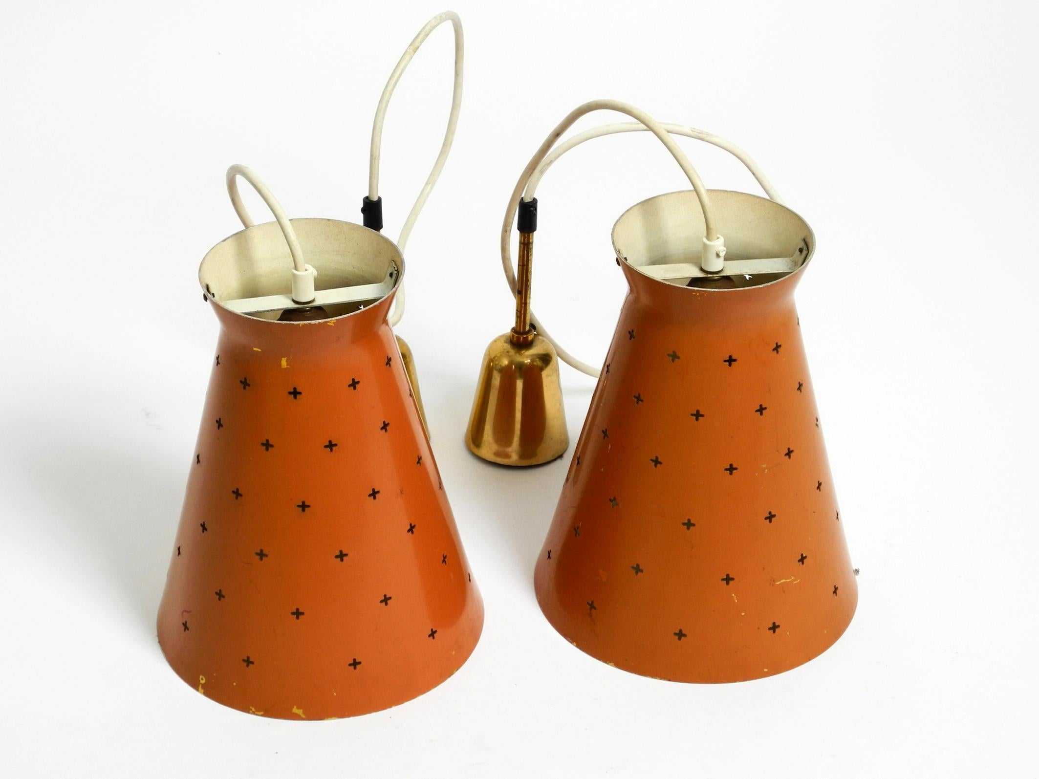 Pair of elegant large Mid Century Modern in Diabolo design perforated metal sheet pendant lamps in brick red. Beautiful minimalist design. Made in Italy.
Inside in light beige. Each with one original E27 brass ceramic socket.
Great light for all