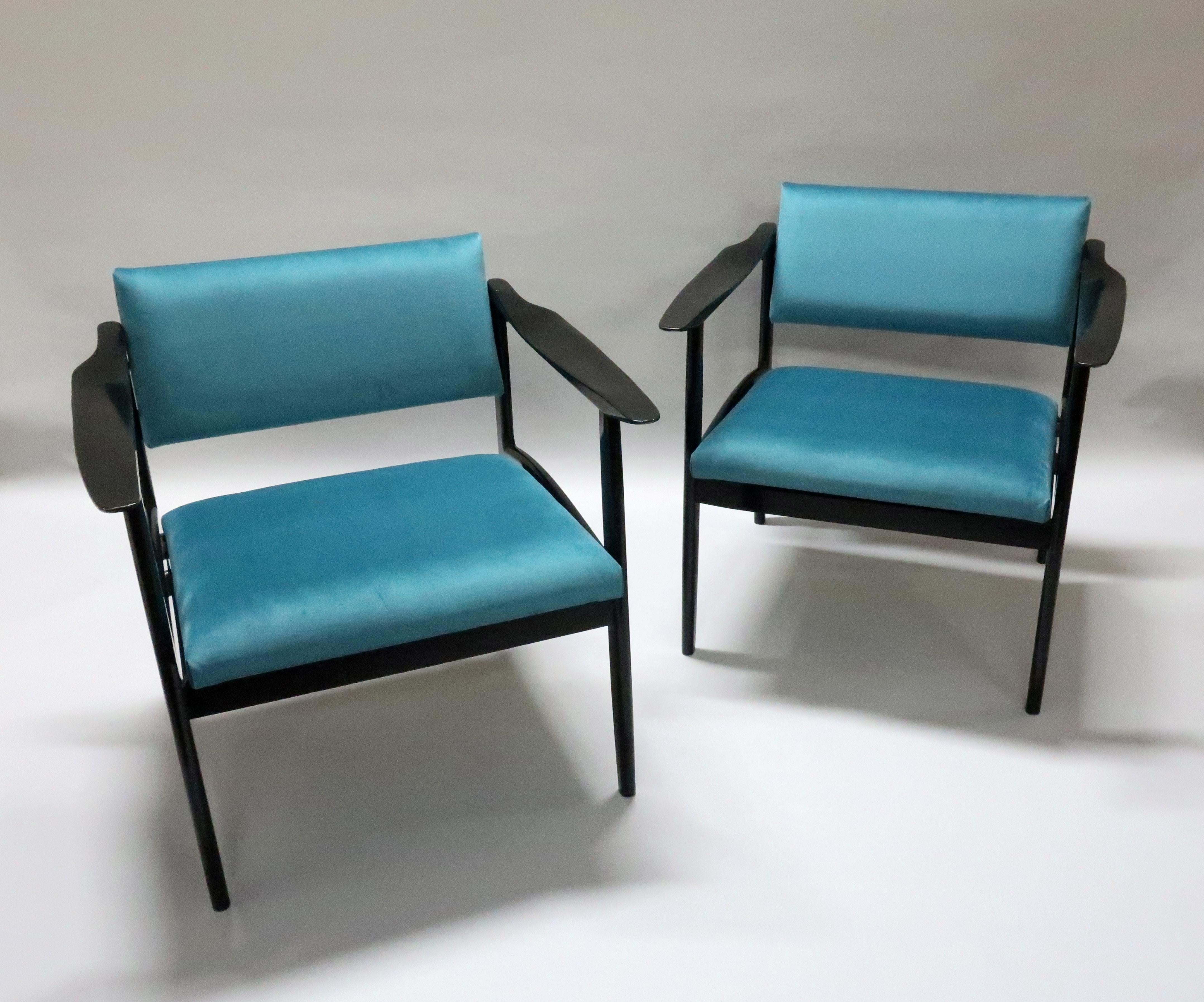A very stylish pair of Italian ebonized Mid-Century Modern armchairs with sleek propeller shaped arms and pivot backs which adjust to your seating position. The chairs have been re-upholstered in a teal colored velvet.