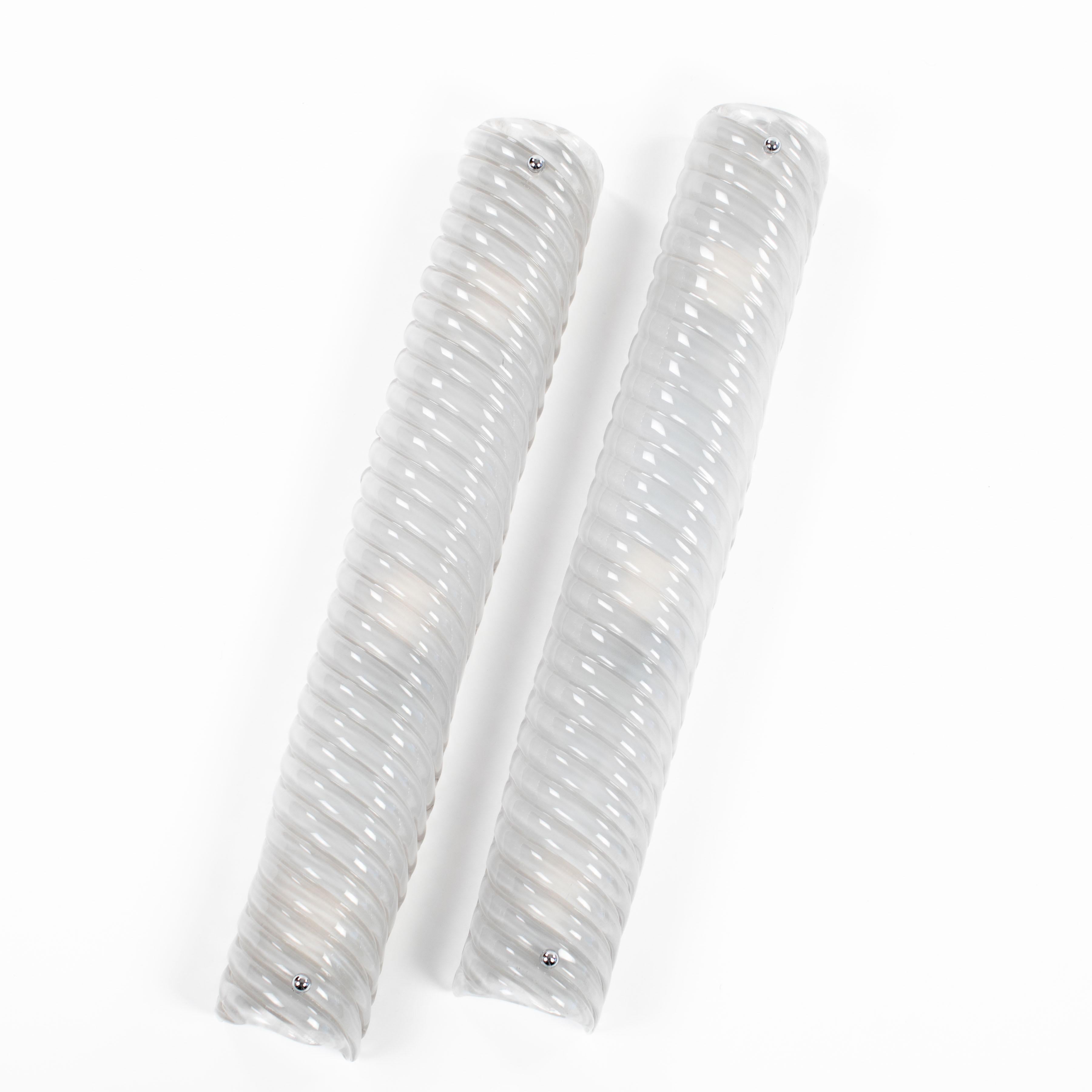 Pair of elegant, Italian late Mid-Century Murano glass wall lamps in silver-grey nickel.

The slim, rounded wall lamps have a cross-ribbed glass shade in a delicate pastel colour mounted on a nickel-plated plate. The shade is attached to the plate