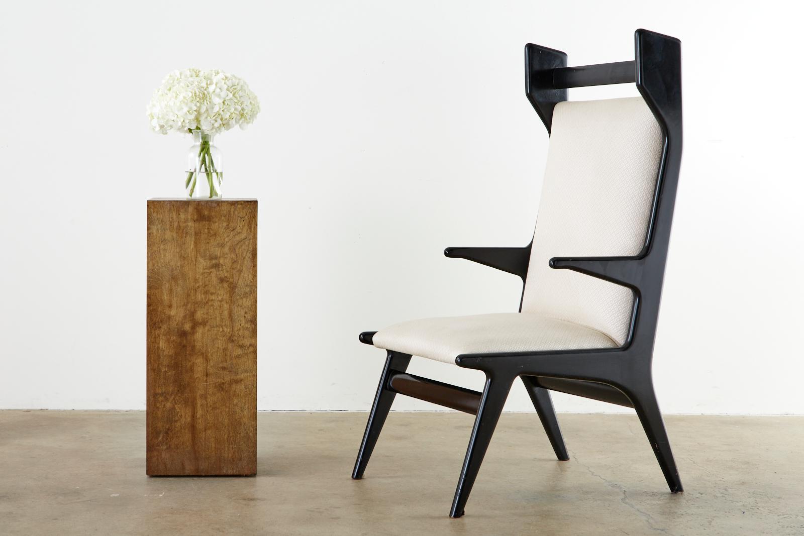 Chic pair of Mid-Century Modern Italian wing armchairs attributed to Ico Parisi featuring a Minimalist style. The frames are ebonized or lacquered wood. These chairs are inspired by iconic midcentury designs by designers such as Hans Wegner and Gio