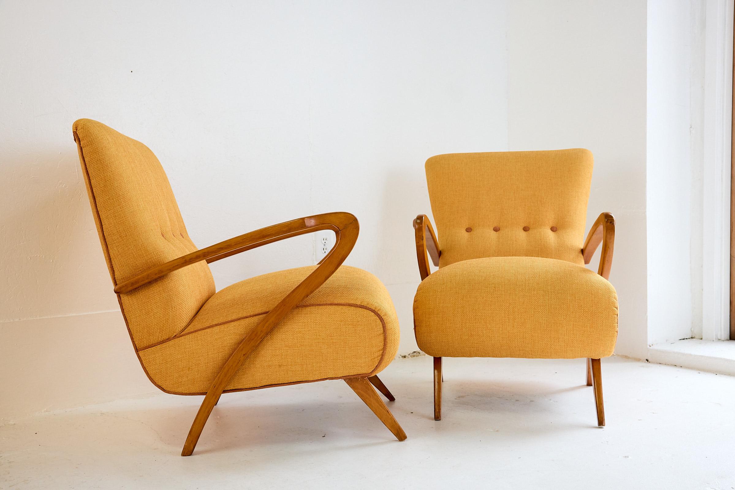 Pair of iconic and highly collectible Italian Mid Century armchairs designed  by Guglielmo Ulrich in the 1950s. The lounge chairs are completely restored with new padding and covered in linen fabric, the armrests and feet are in curved walnut, also