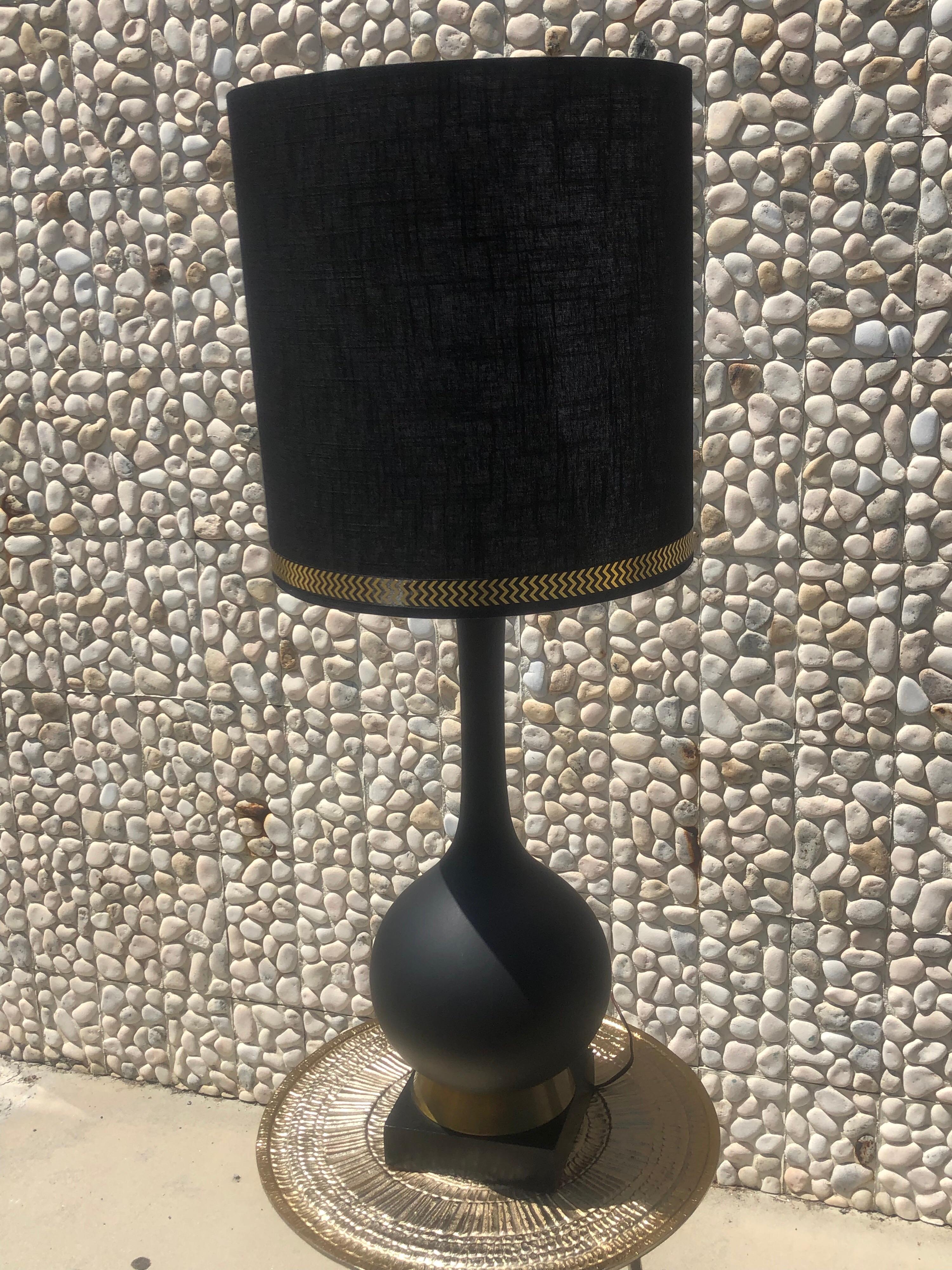 These beautiful midcentury Italian lamps cane from a vintage Palm Springs Estate. We have added a new custom black shade with metallic gold jacquard trim to accent the original brass trim on the bottom of the lamps. Matte black ceramic. Very chic