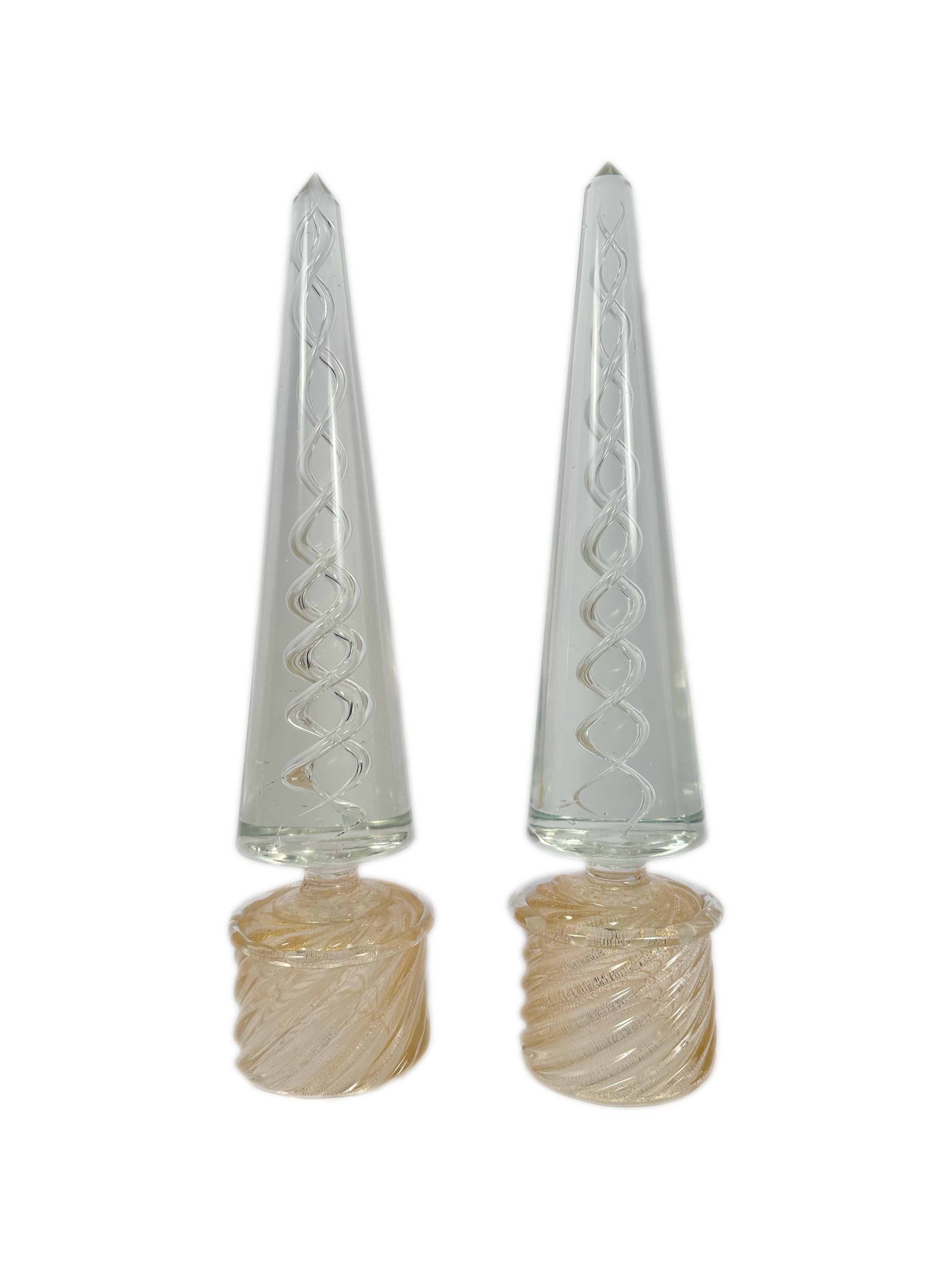 Pair of Murano Italian Mid Century Modern Art Glass Obelisks each decorated with clear lattice/spiral decoration cased in heavy clear glass further decorated gold speckled and scalloped bases. The obelisks are unsigned. circa 1960s.

Measurements: