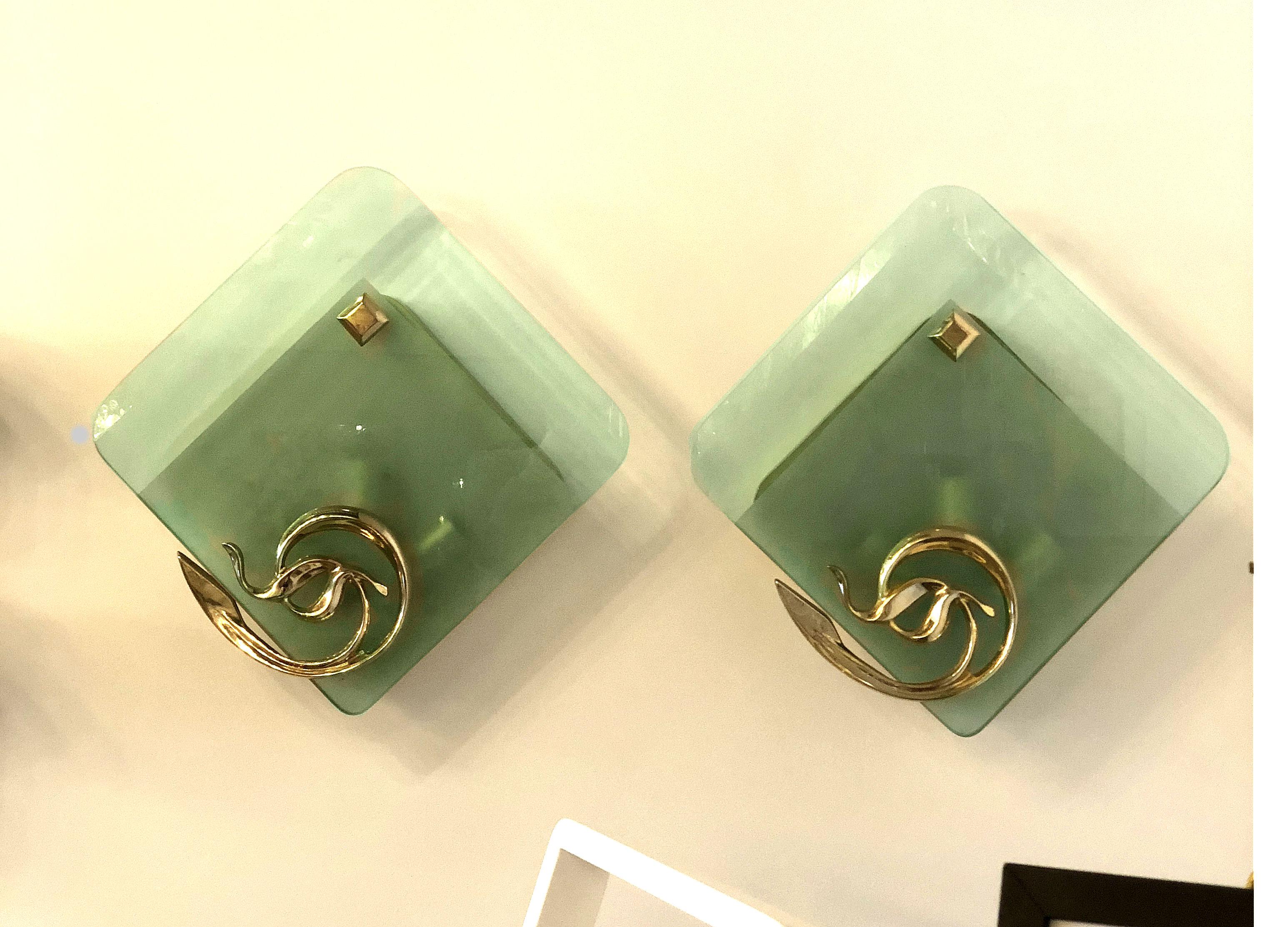 Pair of Italian, Mid-Century Modern sconces, or flush mounts, attributed to Fontana Arte, circa 1960.
Made of cast brass mounts and ornaments, and a large thick green glass square, partly frosted, hiding 3 lights each.
Beautiful quality &
