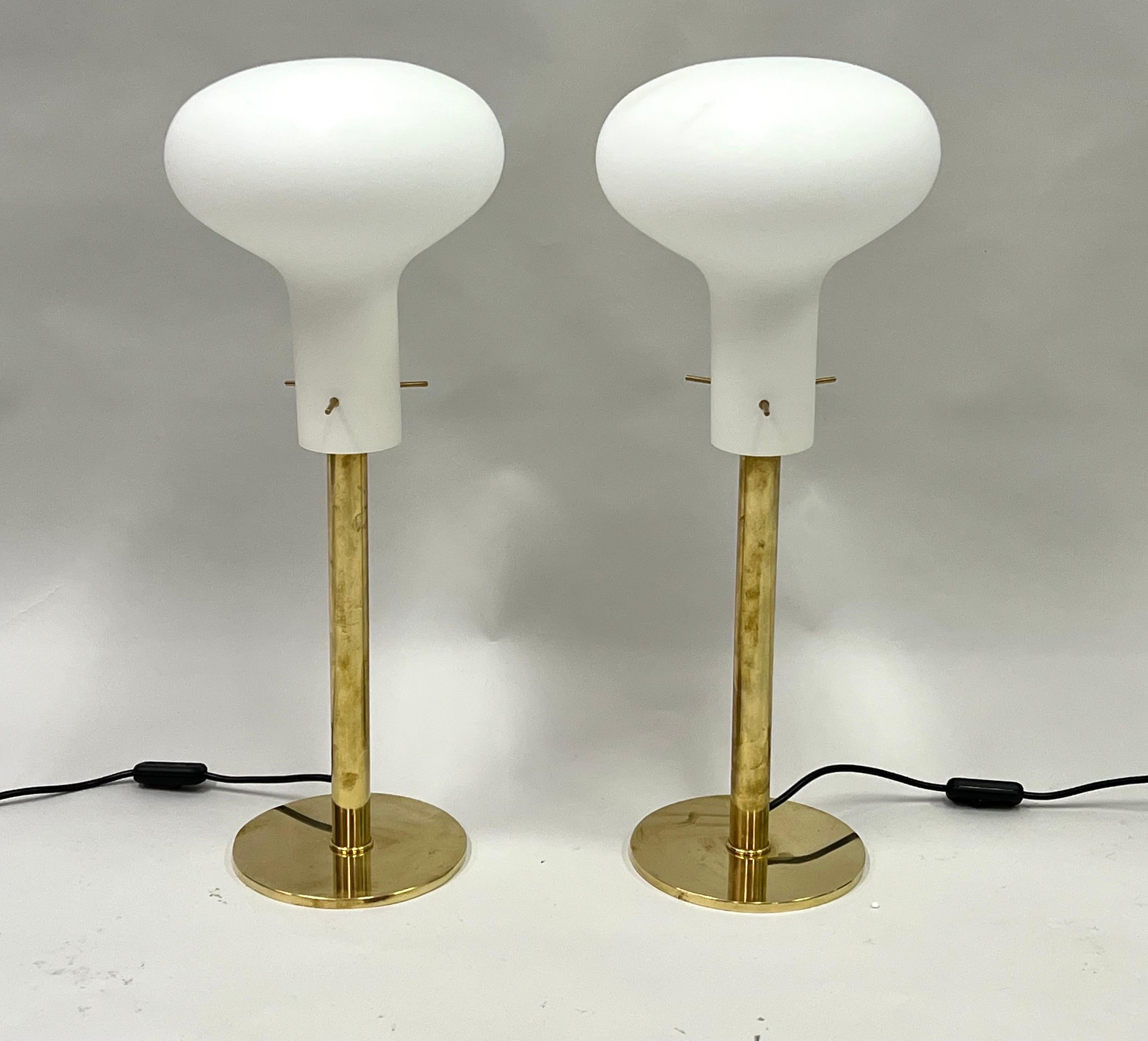 An elegant and timeless pair of Italian Mid-Century Modern table lamps attributed to Max Ingrand and Fontana Arte. The table lamps are of rare design and the highest quality of manufacture. They feature an original form with a pure, round brass base