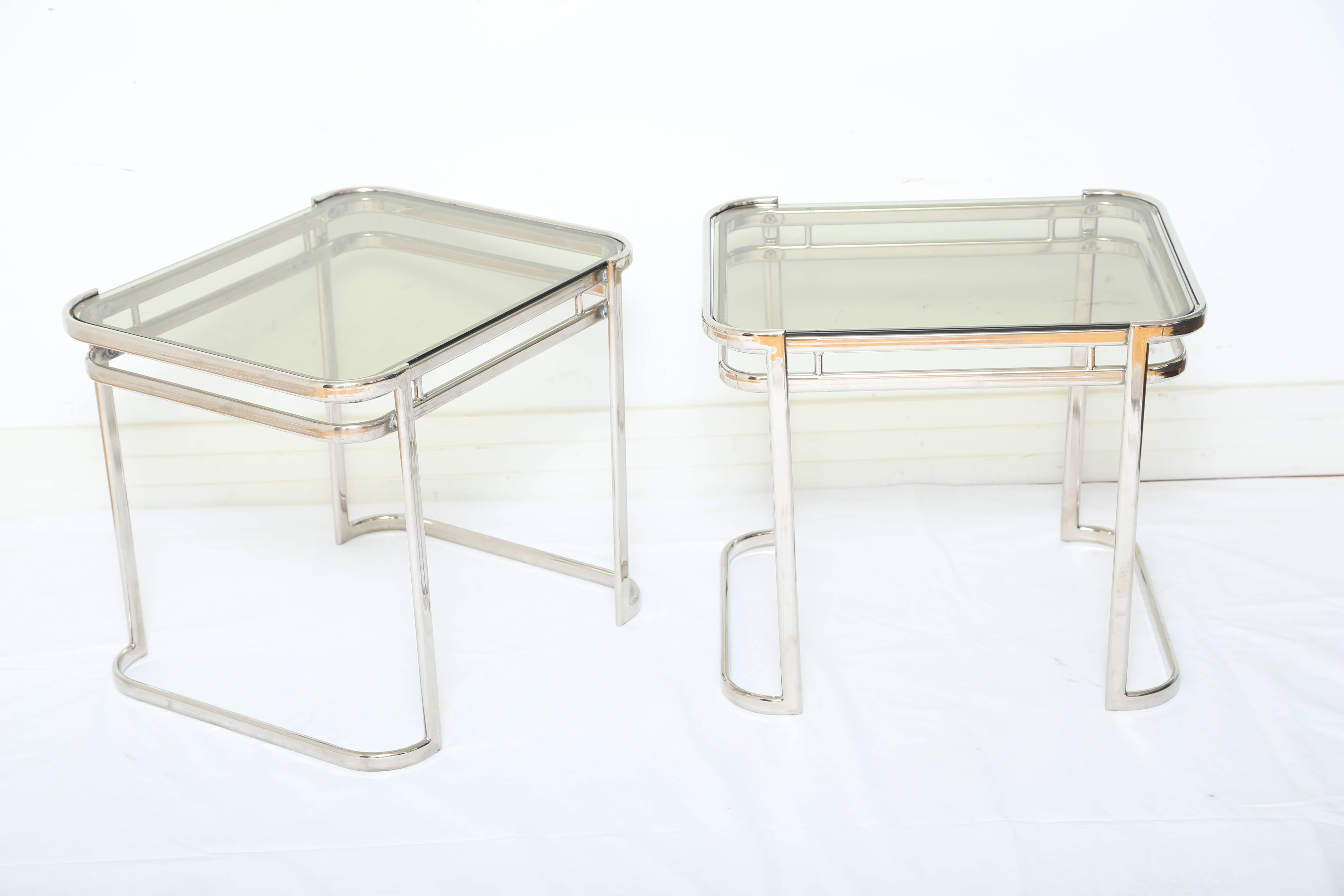 Pair of sleek midcentury side tables with streamline design. The tables feature curved corners with double banded frames and curved legs or bases. The tables have a small rectangular form and be used horizontally or vertically. Fitted with smoked