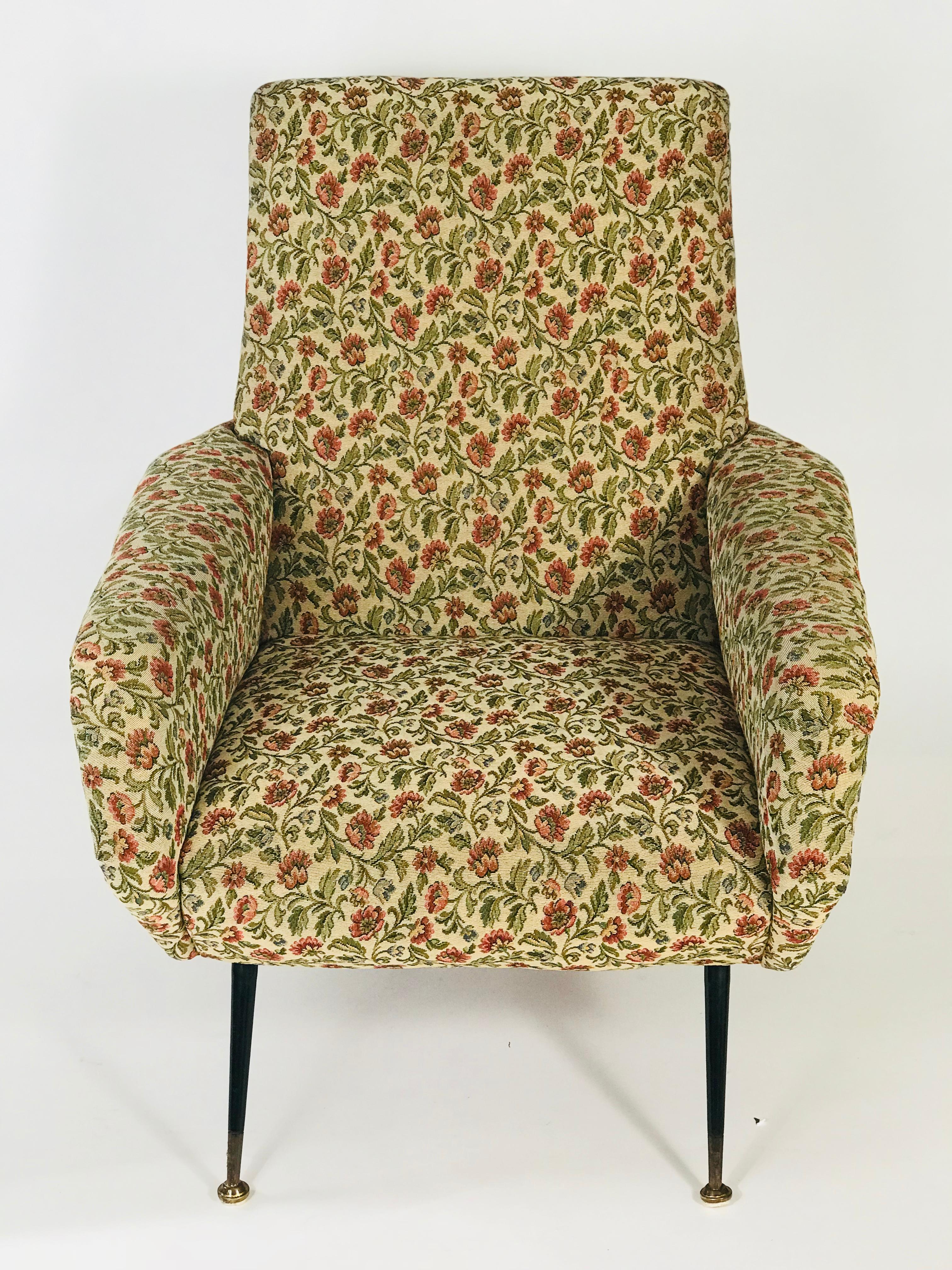 A pair of Italian midcentury lounge chairs upholstered in the original 1950s woven floral tapestry with two button-tufts, raised on metal legs with brass sabots, circa 1950. Arrived out a home in Rome. These chairs are substantial and well made.