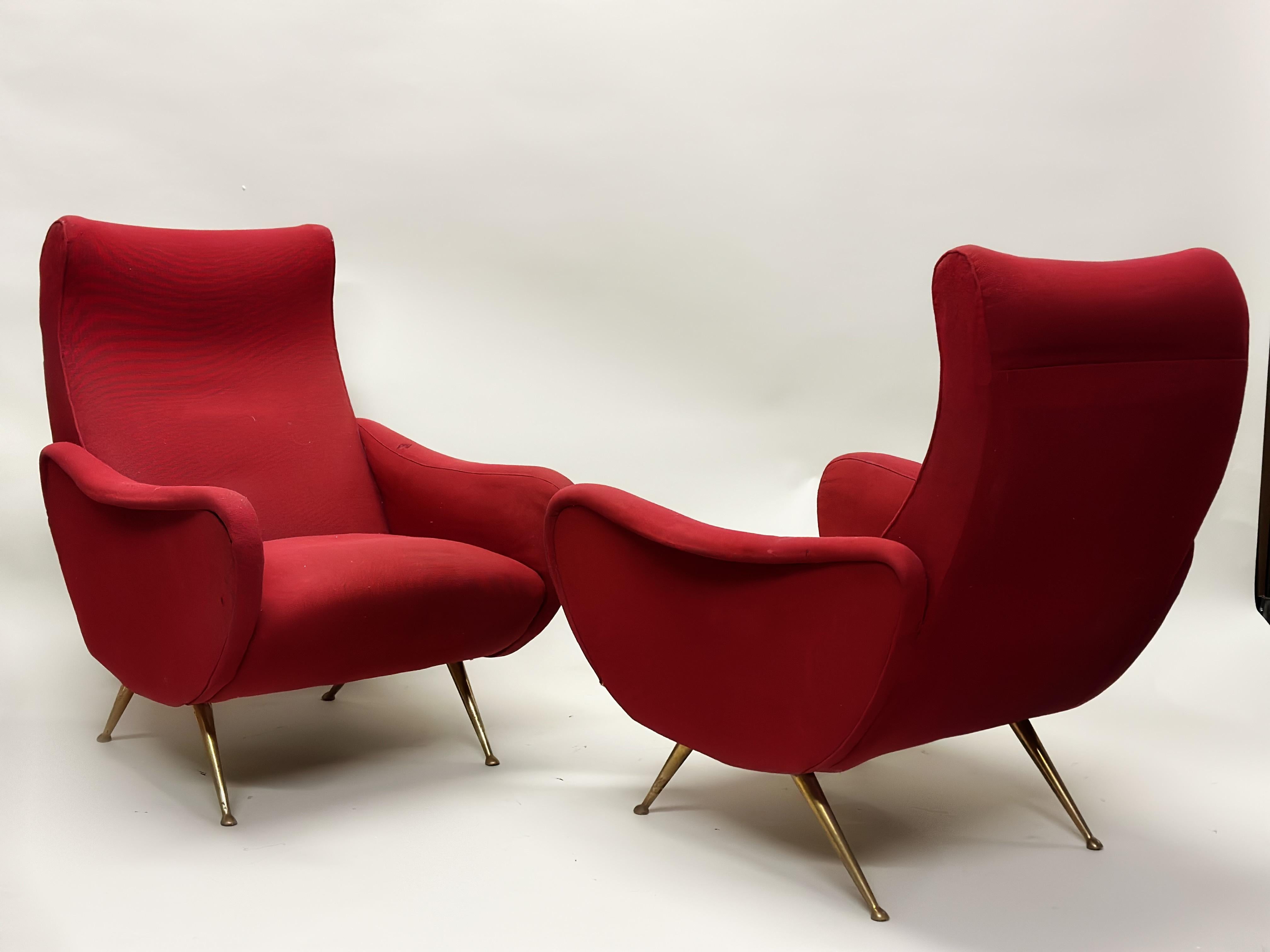 A classic pair of Italian Mid-Century Modern lounge chairs or Armchairs in the style of Marco Zanuso's 'Lady Chairs'. The chairs are set upon a set on boldly angled and tapered solid brass legs and sabots. The overall form is sensuous and organic