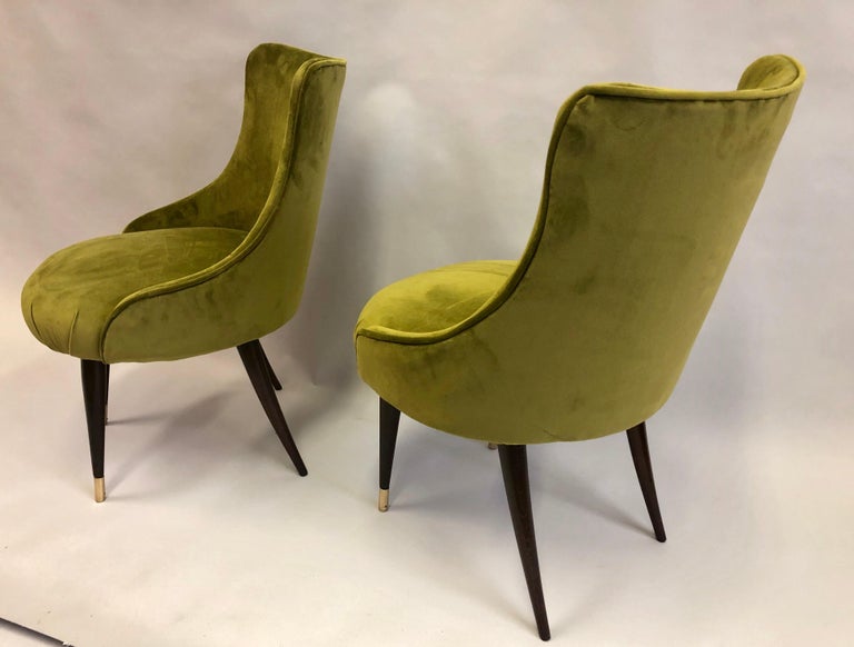Elegant pair of Italian Mid-Century Modern neoclassical wood and upholstery slipper / lounge chairs / armchairs by Guglielmo Ulrich.

The pieces feature round sculpted backs with gently receding armrests and they are set upon angled, tapered, wood