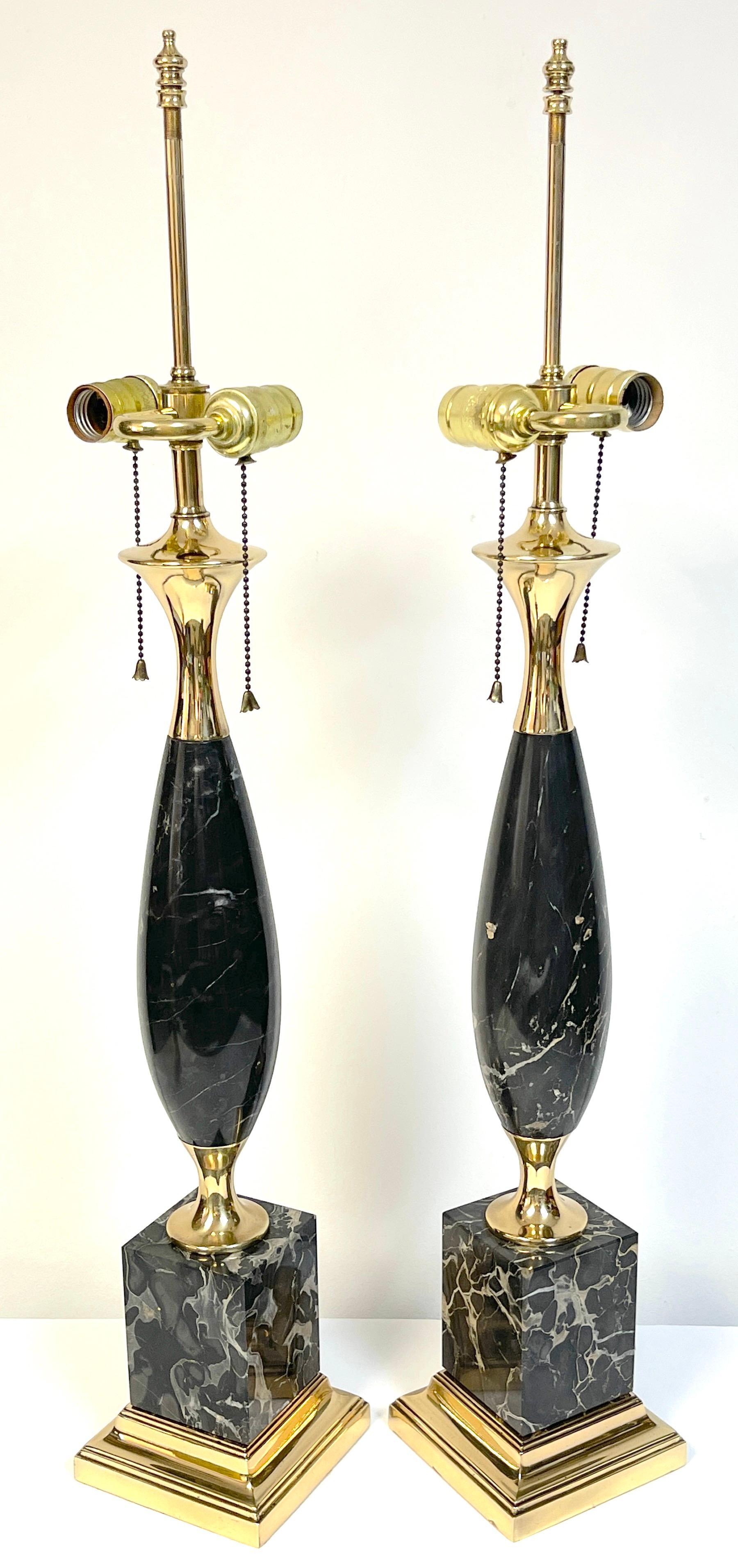 Pair of Italian Mid-Century Modern sleek black marble & brass lamps
Italy, circa 1960s

Each one with polished brass mounts, the tapering oval column of specimen black and white marble, joined with a brass pedestal resting on a square black and