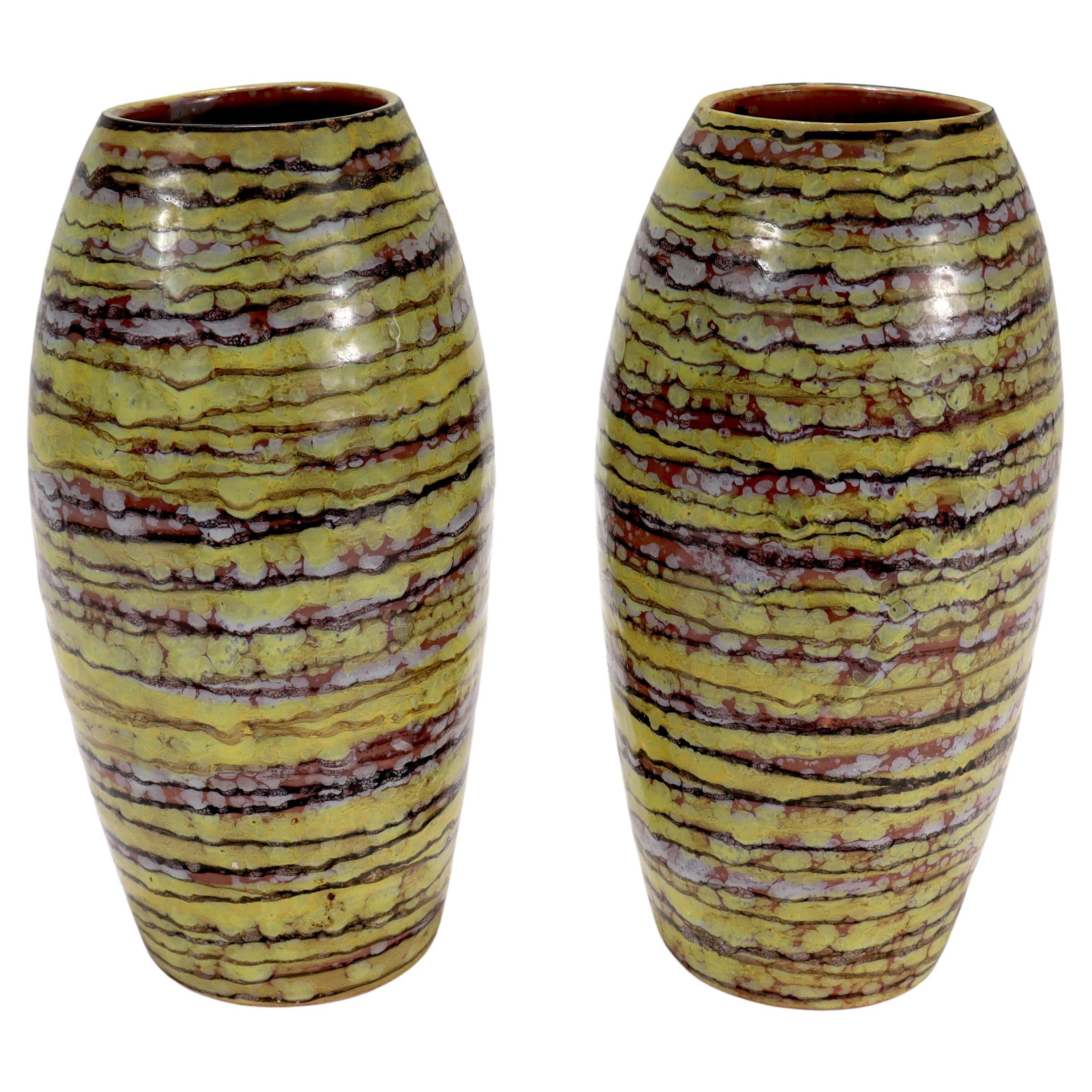A fine pair of Mid-Century Modern Italian terracotta vases.

Both vases have primarily yellow glazes, with stripes of brownish-red and spots of white.

In the style of Guido Gambone or Marcello Fantoni

Marked to the base 
