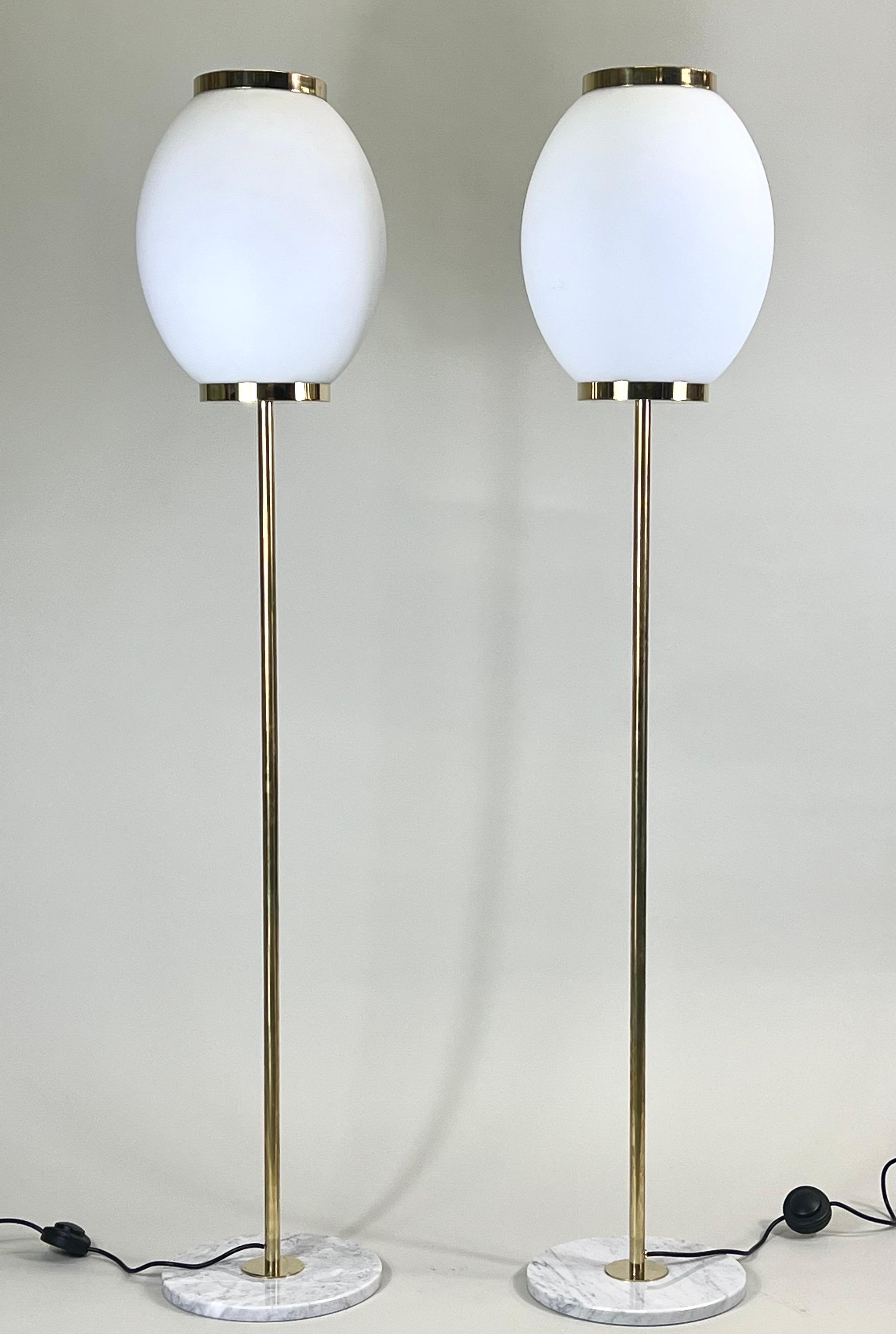 Elegant pair of Italian Mid-Century Modern style floor lamps attributed to Max Ingrand and Fontana Arte. The standing lamps have an understated, refined form and are composed of beautiful, complimentary materials. The pieces rest on round Italian