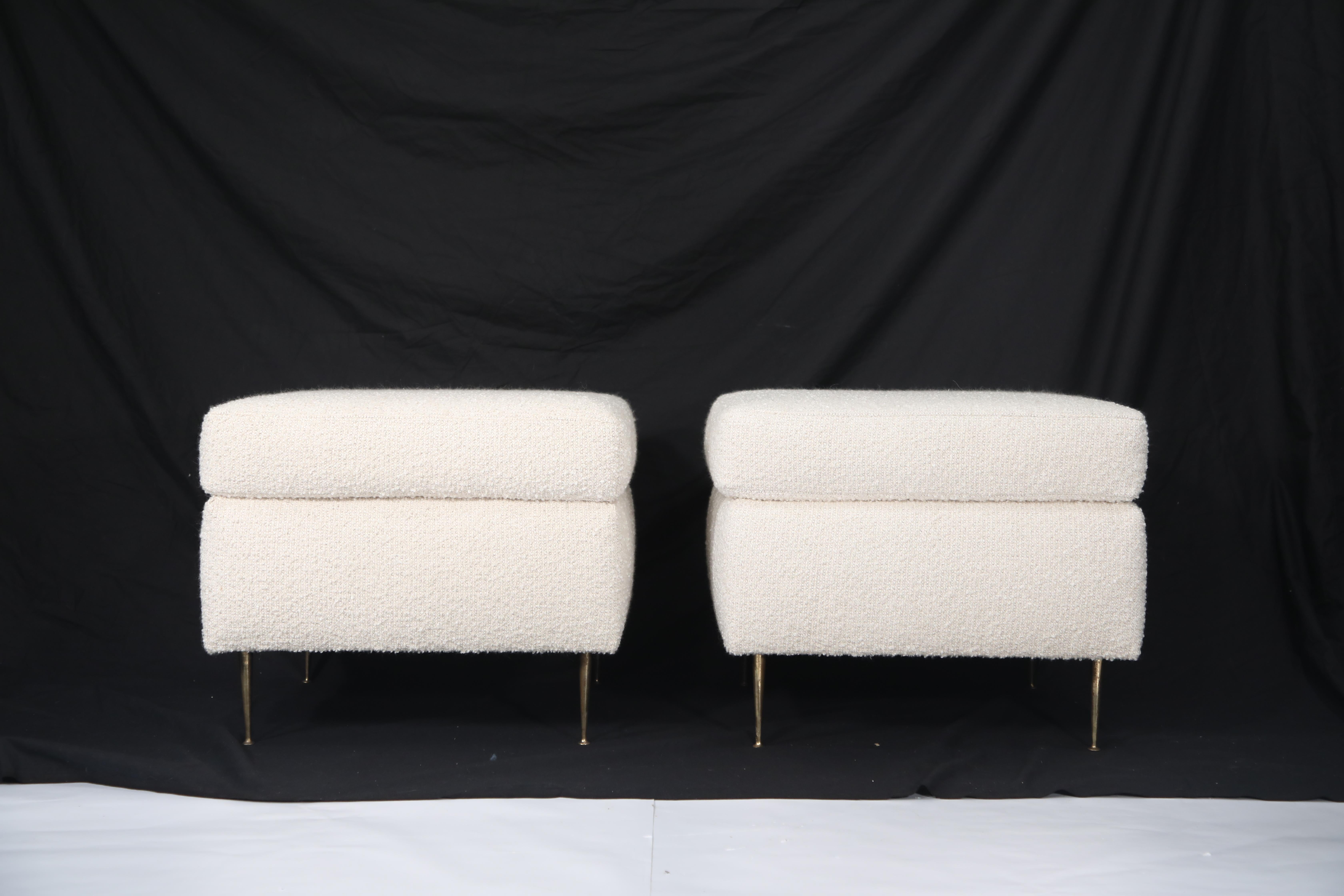 A gorgeous pair of Italian Mid-Century Modern white bouclé ottomans on brass legs. This magnificent pair of poufs are designer on-trend and ready to be used immediately. Completely restored, the white nubby bouclé is beautiful and the brass legs on