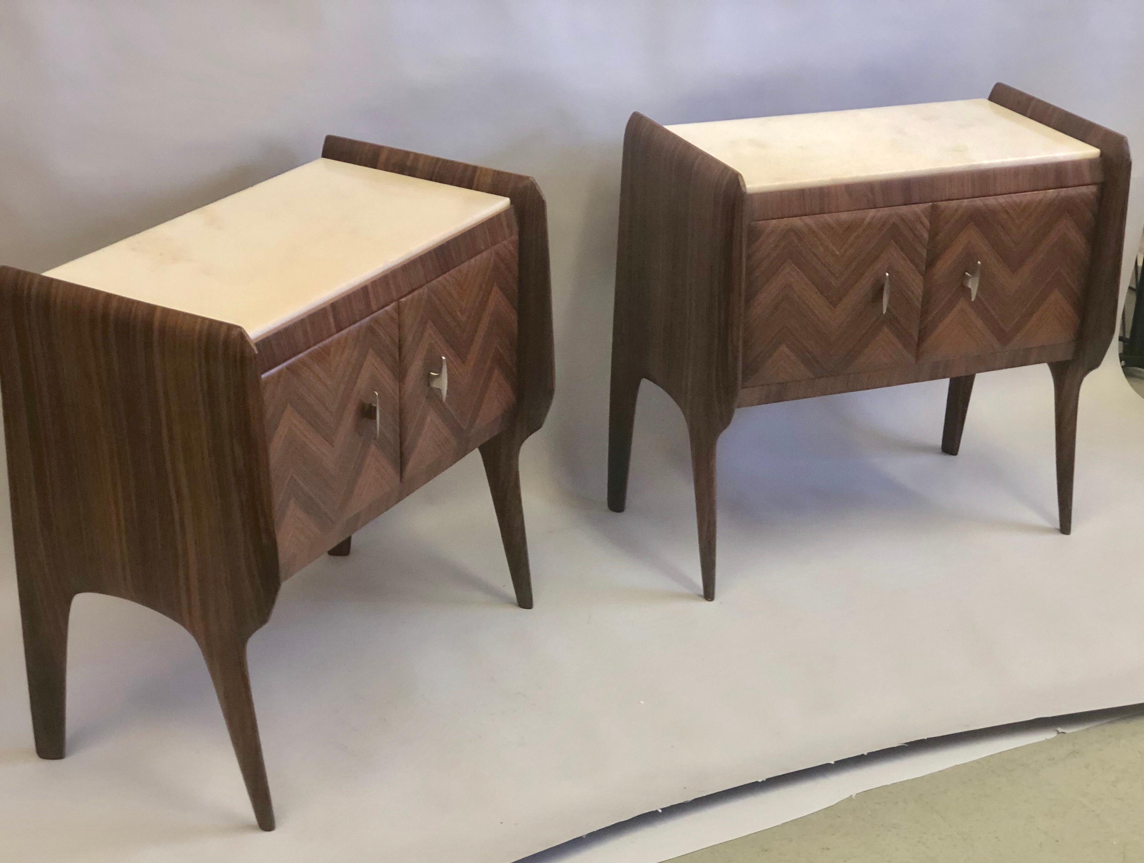 Pair of Italian Mid-Century Modern nightstands / end tables / side tables attributed to Osvaldo Borsani. Inlaid mahogany in chevron pattern with white marble tops. Doors open and contain storage.