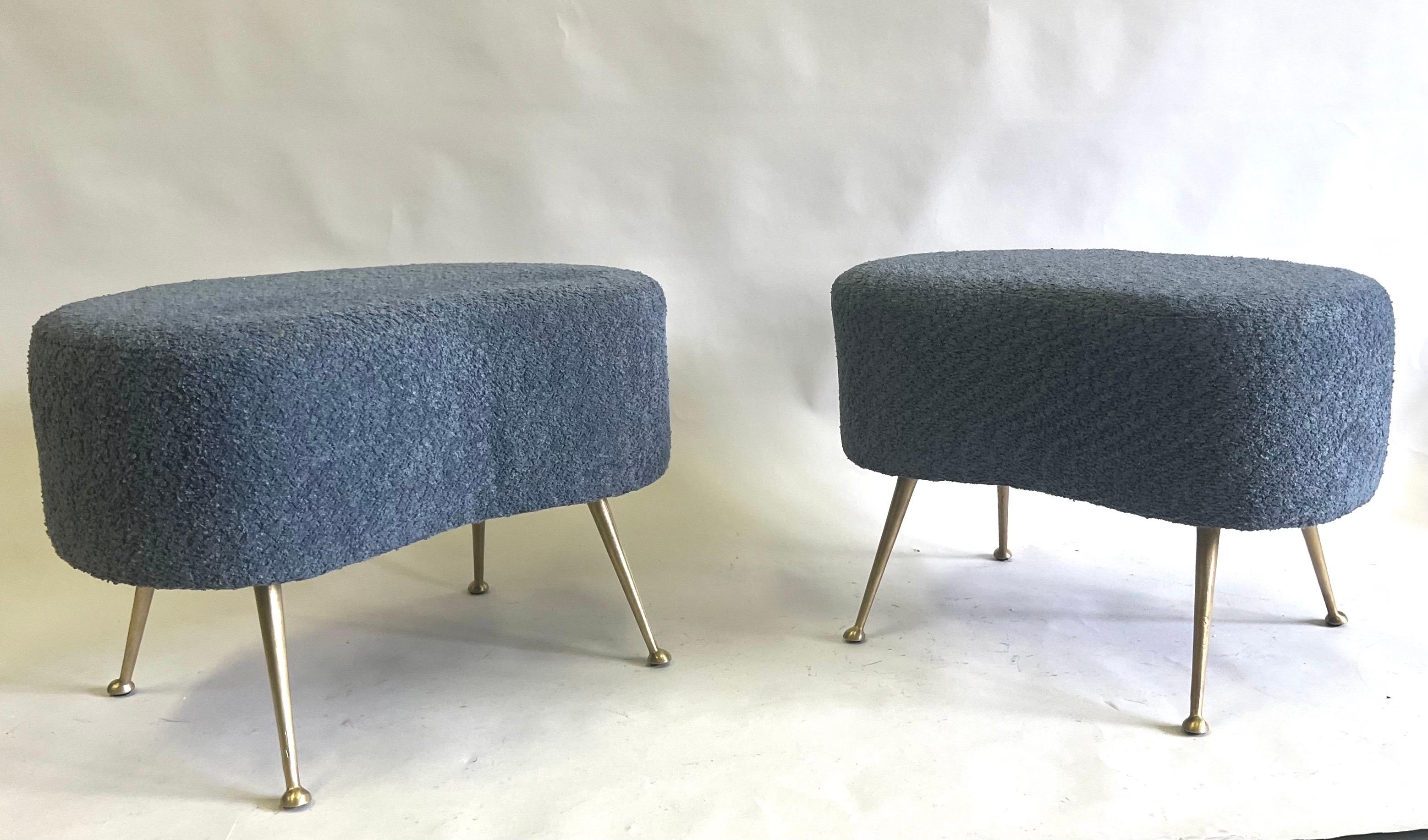 An Elegant Pair of Italian Midcentury Modern Organic Form Stools / Benches / Ottomans / Poofs in the style of Marco Zanuso circa 1953. The pieces feature a delicate organic curved form and rest on 4 splayed solid brass legs. They are covered in a