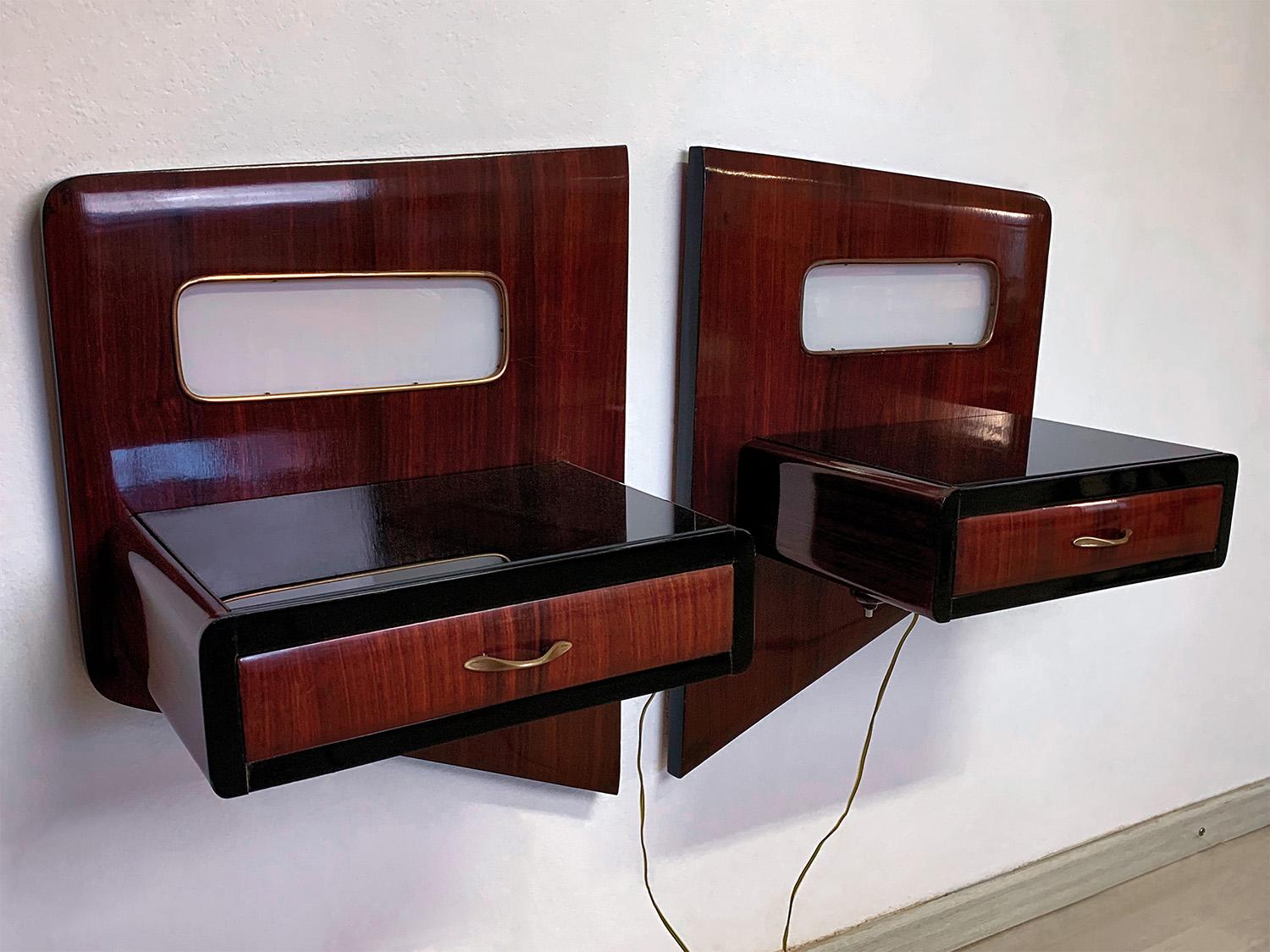Pair of stylish Italian suspended Nightstands in mahogany wood, designed and manufactured by Vittorio Dassi in the 1950s.
Each nightstand has a drawer surmounted by a black glass top and is equipped with perfectly functioning light, under which the