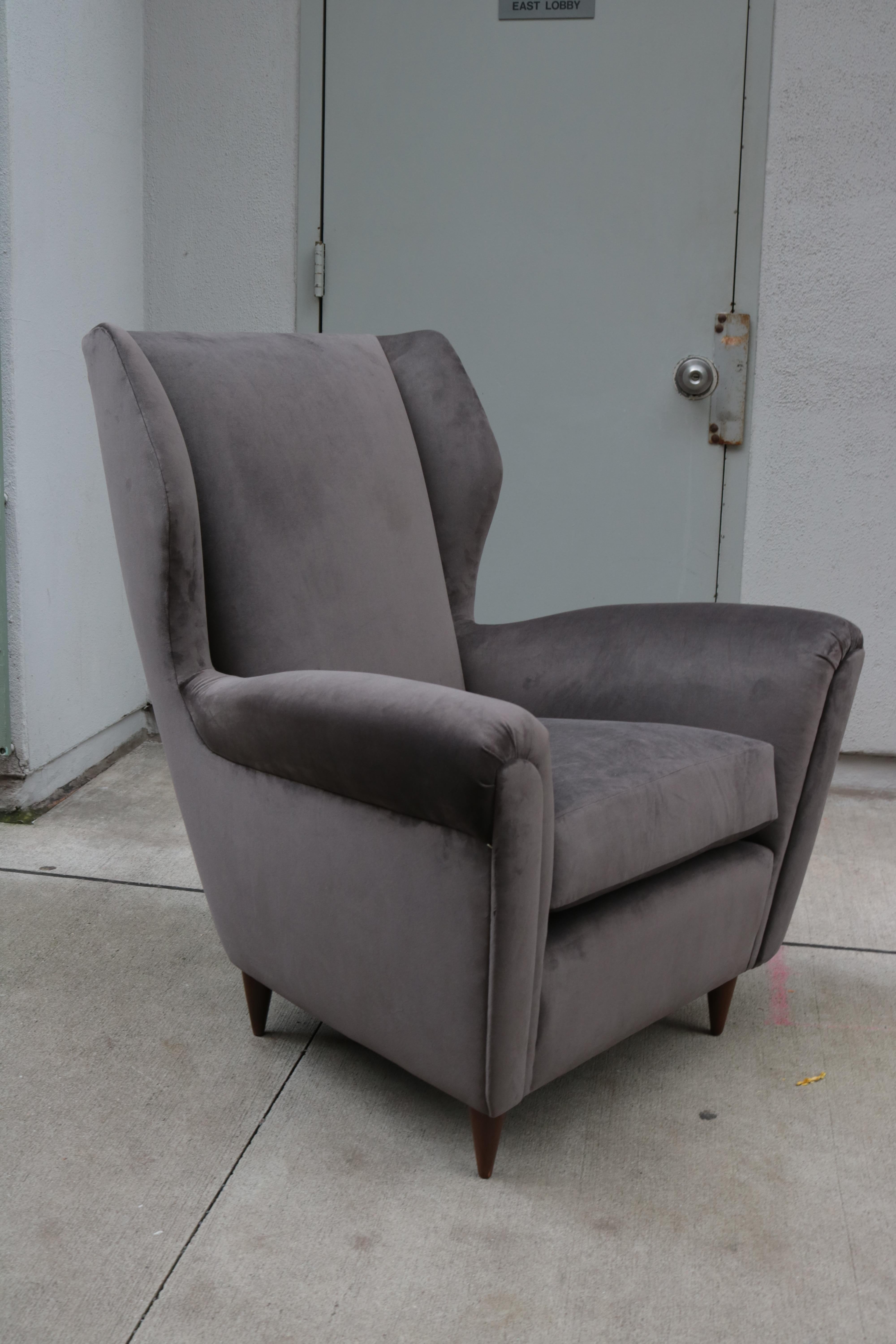 Pair of wing chairs attributed to Gio Ponti. 
Newly reupholstered structurally reinforced on walnut legs.