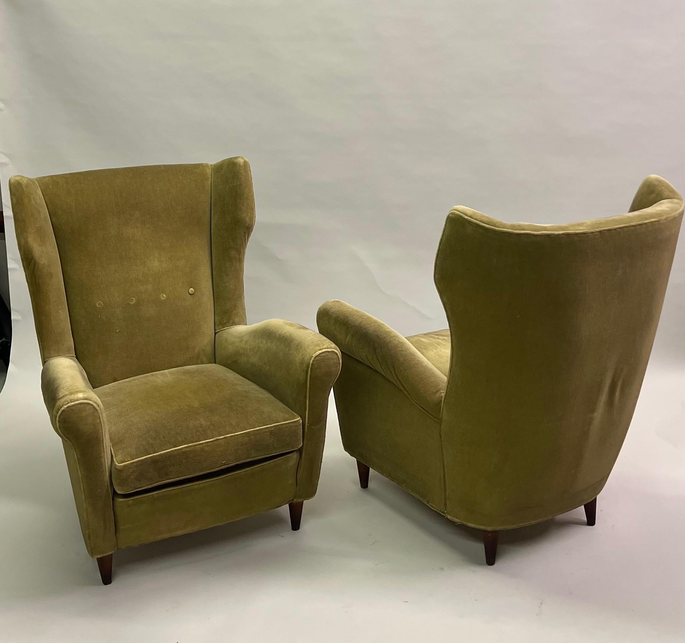 An elegant, stunning pair of Italian Mid-Century Modern armchairs or lounge or wingback or high back chairs attributed to Gio Ponti, 1955 . Gio Ponti was known for working in the Modern Neoclassical style; these chairs reflect that and can define