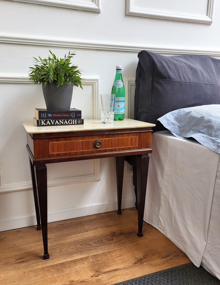 Very elegant and refined Italian 1950s neoclassical pair of bedside tables with inlay walnut veneer wood, drawer with brass handle, spade square legs and white marble top. Those nightstands make a great look in any style bedroom, as a complementary