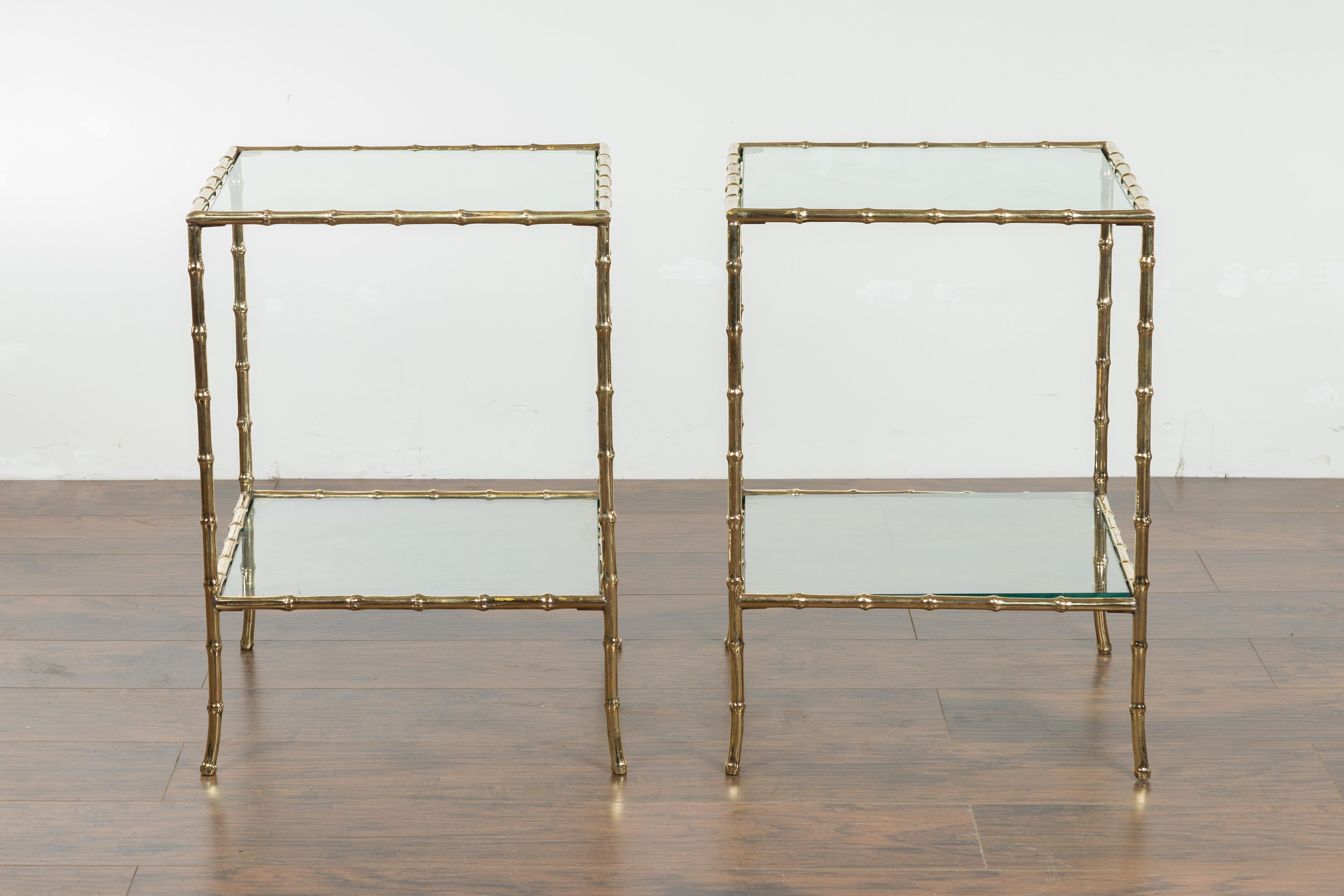 A pair of Italian bronze faux-bamboo end tables from the mid-20th century, with glass tops and shelves. Created in Italy during the midcentury period, each of this pair of end tables features a square-shaped glass top secured within a faux bamboo