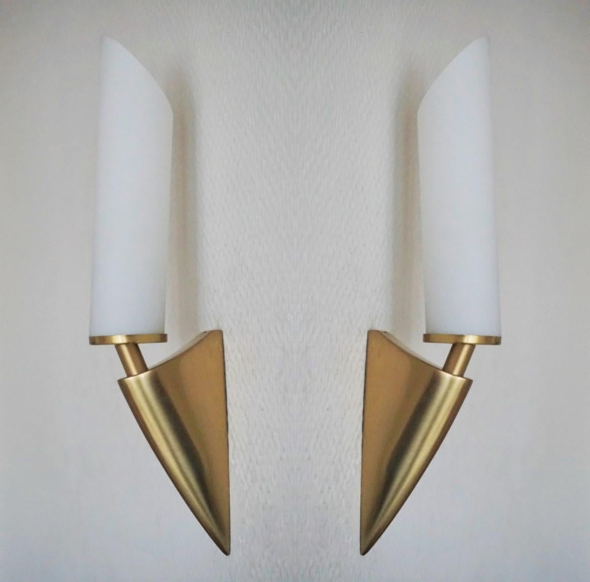 A pair of midcentury Italian design wall lights with brushed brass base and satin glass shades, Italy, 1950-1959. 
Each sconce takes one E14 40watt light bulb.
Measures: Height 10