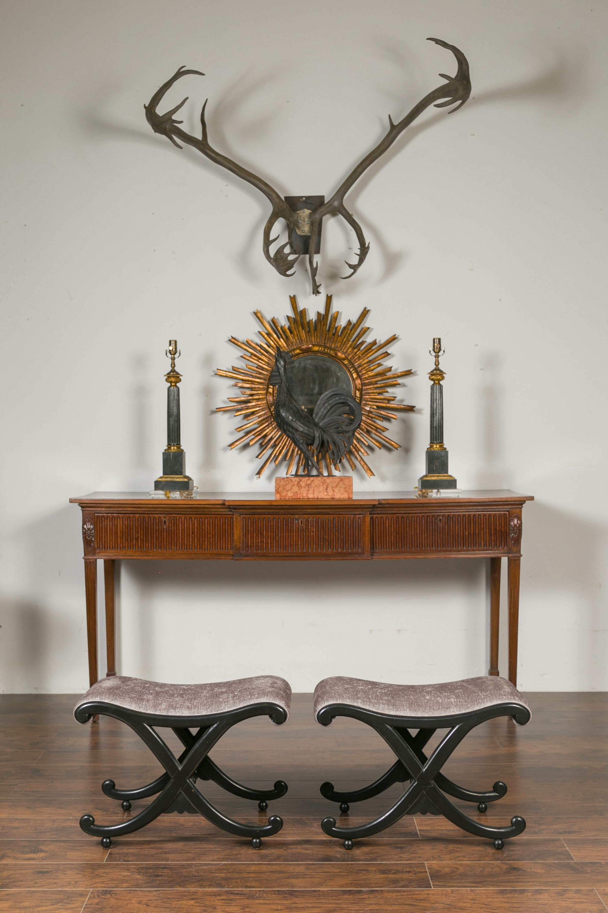 A pair of Italian vintage ebonized wood stools from the mid-20th century, with X-form base and upholstered seats. Born in Italy during the midcentury period, each of this pair of stools features a curving top covered with a grey colored upholstery,