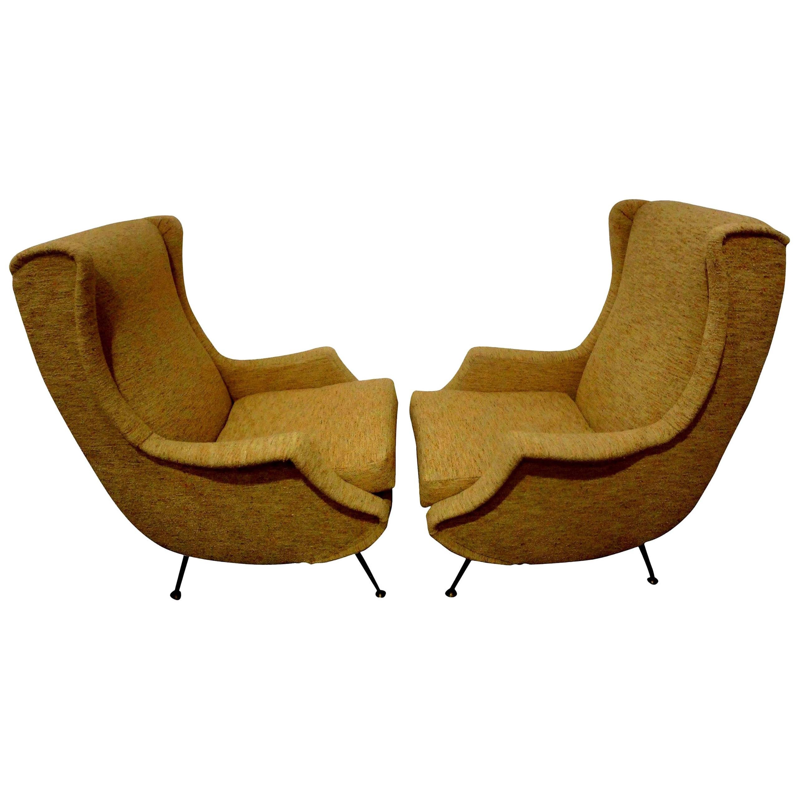 Pair of Italian mid-century lounge chairs inspired by Gio Ponti. Sculptural and comfortable pair of Italian modern lounge chairs, club chairs, armchairs or bergeres. These Italian mid-century lounge chairs with splayed brass legs were taken down to