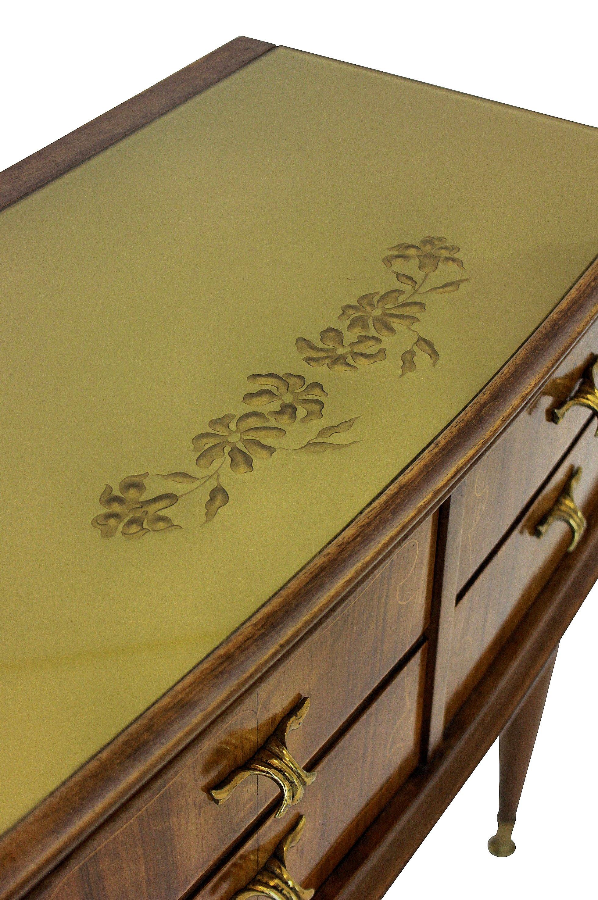 A pair of Italian midcentury nightstands in walnut, with figuring. Each having two drawers and a cupboard, with the original glass tops and brass fittings.
 