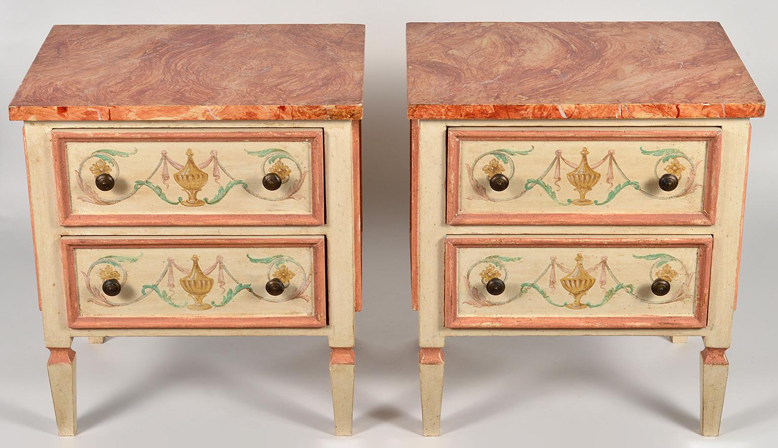 These charming 20th century commodes or night stands feature marbleised tops above two paneled drawers painted and decorated in the classical style with scrolls and urns. The commodes are painted and similarly decorated on all sides.