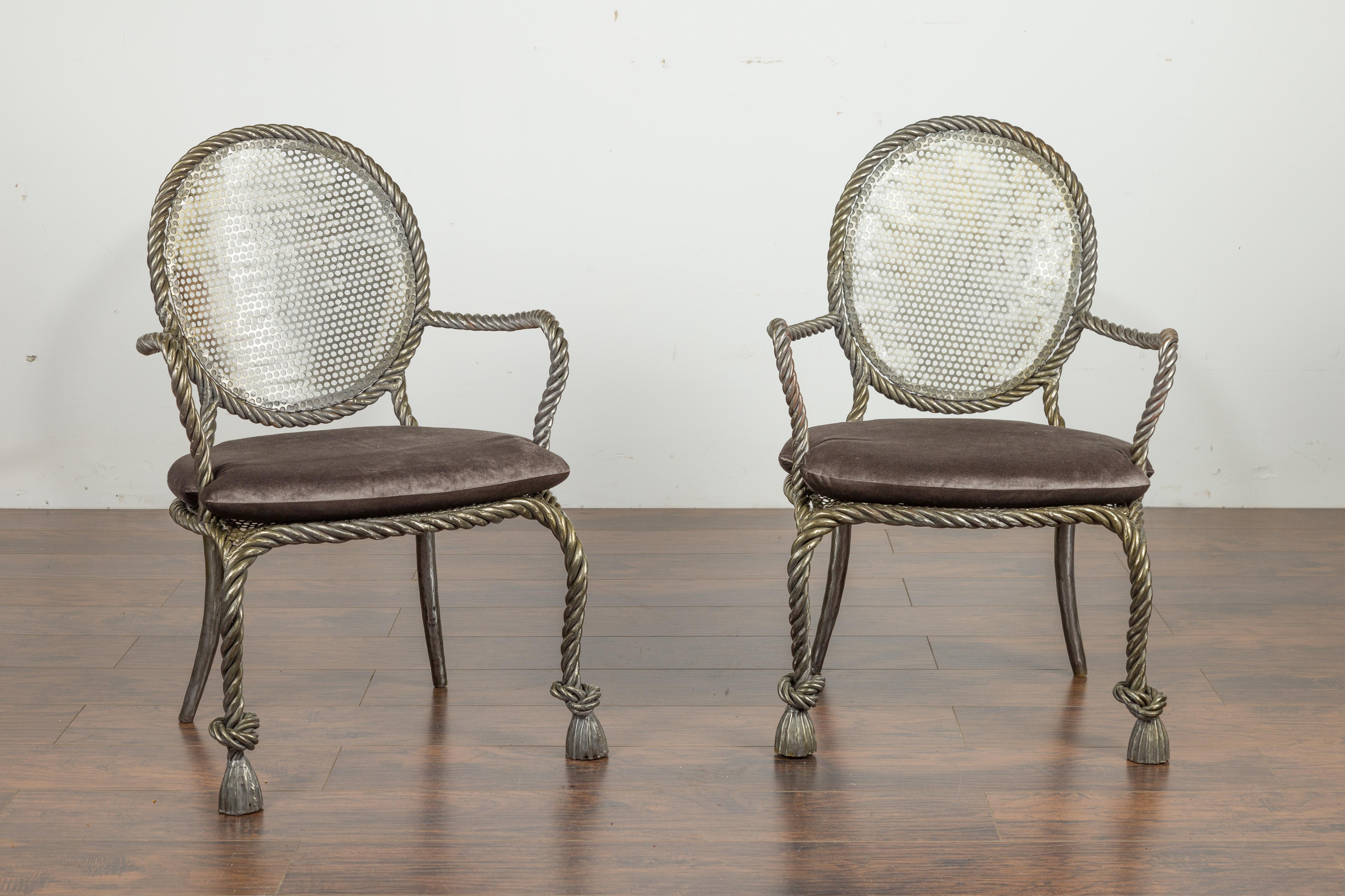 A pair of Italian polished steel rope armchairs from the mid-20th century, with tassel feet and grey velvet cushion. Created in Italy during the midcentury period, each of this pair of steel armchairs features a striking rope design perfectly