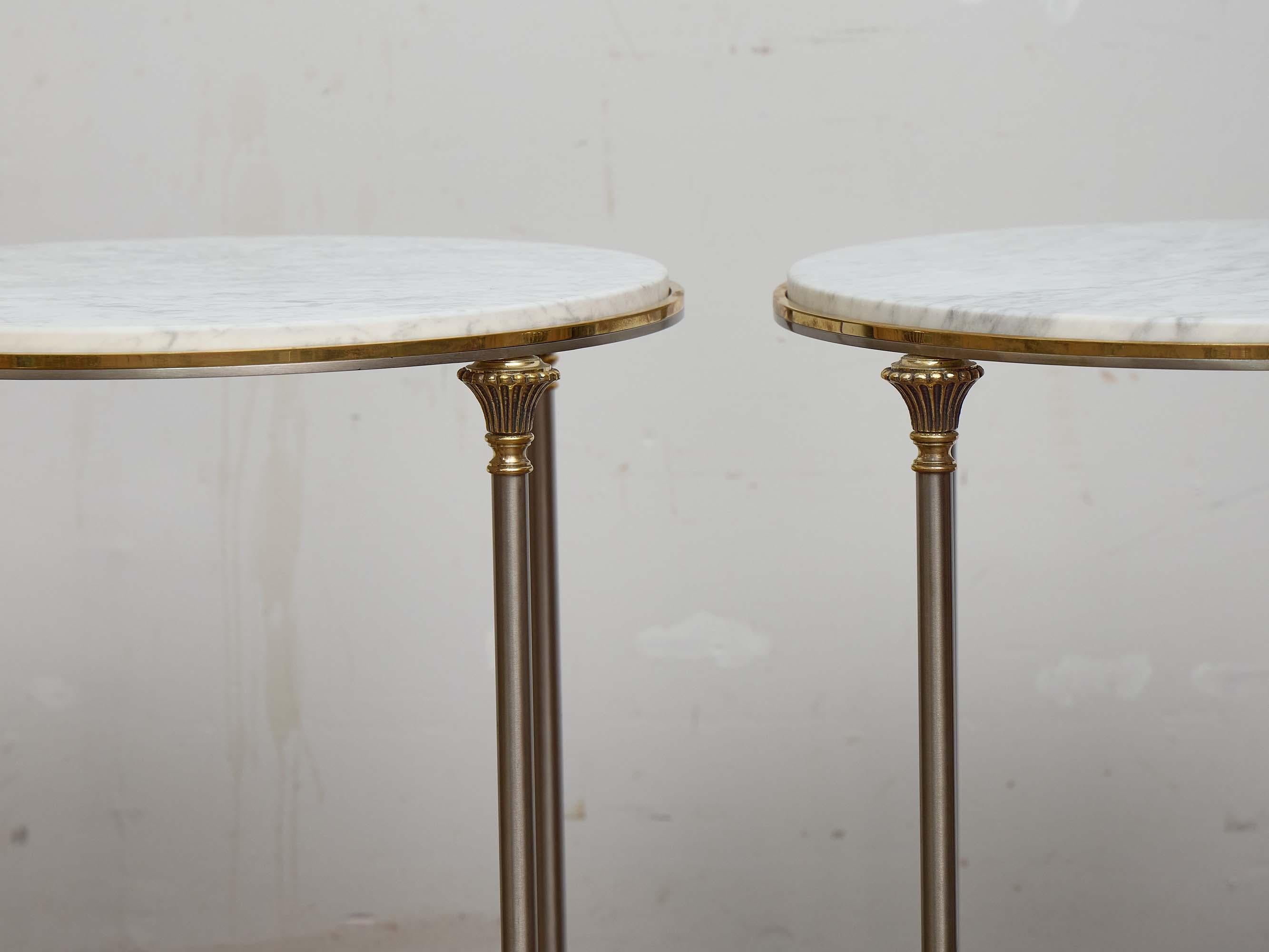 Dieses elegante Paar italienischer Beistelltische aus der Mitte des Jahrhunderts verbindet neoklassische Einflüsse mit schlichtem modernistischem Feingefühl. Jeder Tisch hat eine runde weiße Marmorplatte mit dezenter Maserung, die von einer schmalen