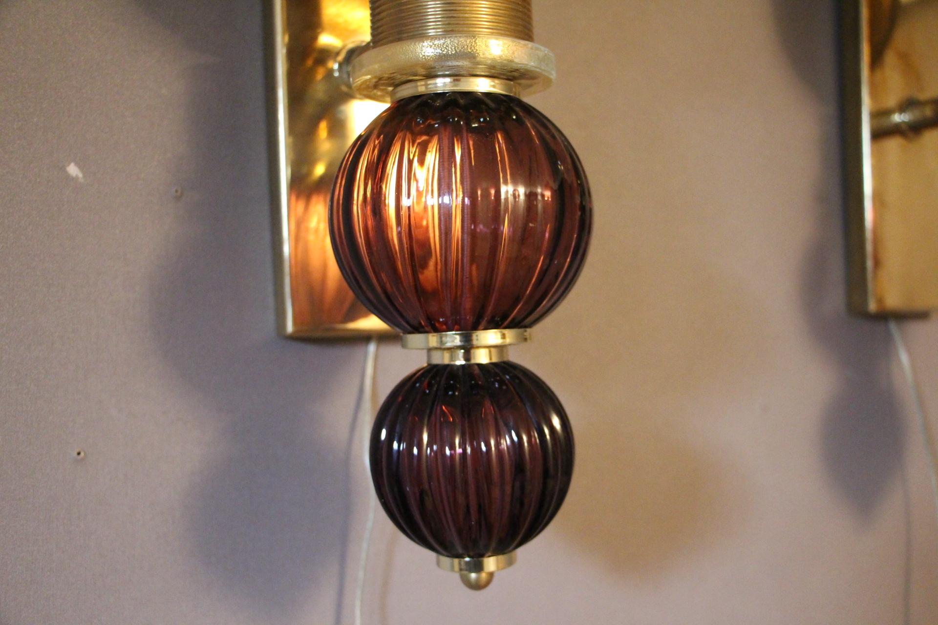 Superb pair of sconces made in brass, two purple Murano glass globes, amethyst color and a golden mercerized Murano glass globe.
 