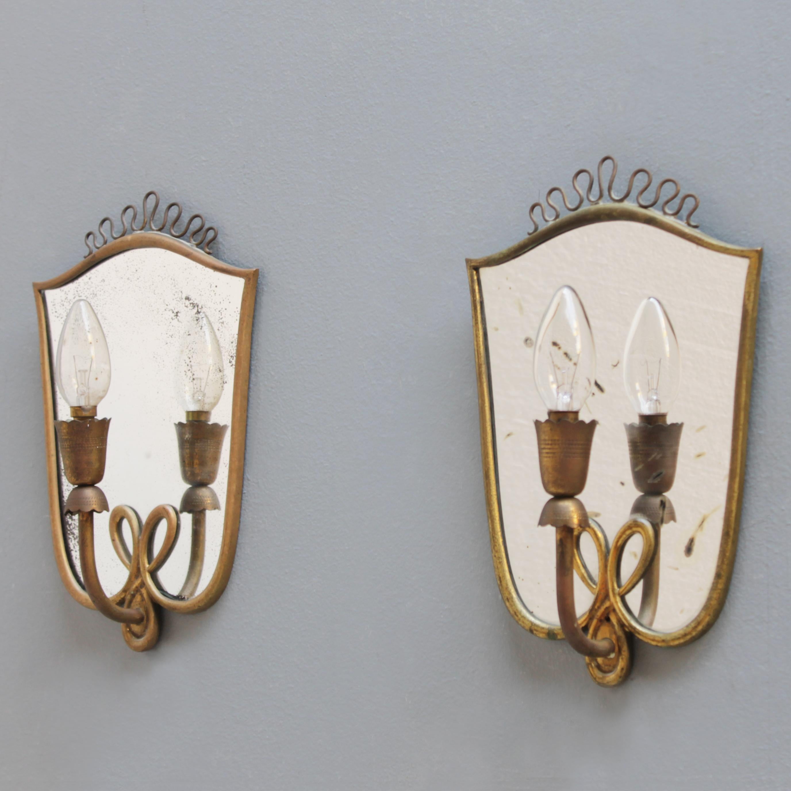 A pair of patinated mirror sconces, executed in the typical Italian Art Deco style of the 1940s and early 1950s.
The fixture is equipped with small Edison screw sockets (SES), (E17 14-17 mm) max 40 watt, works in the USA.
Dimensions: height 11.8