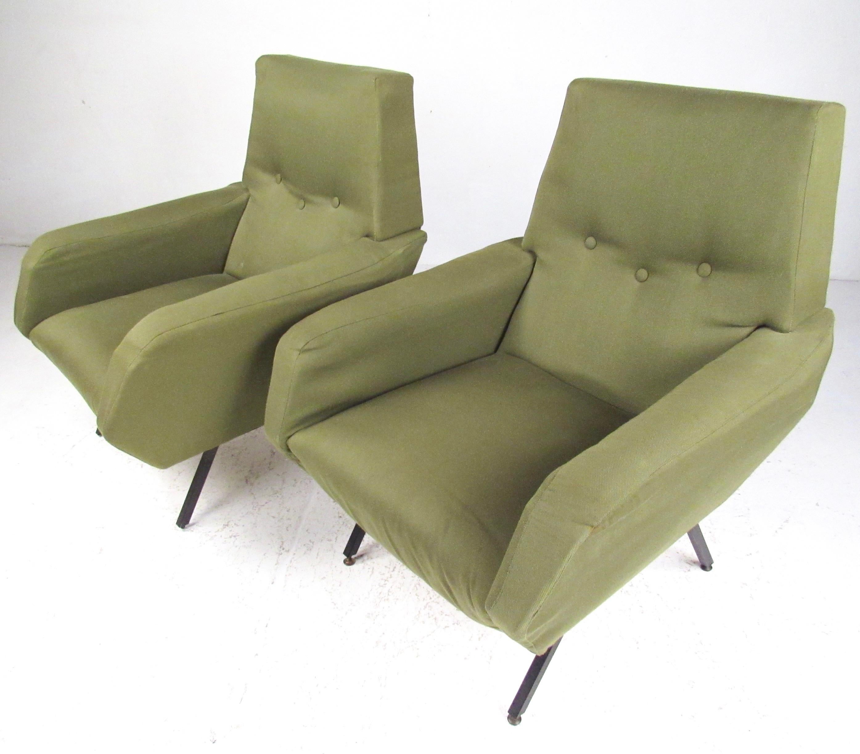 This striking pair of Osvaldo Borsani style lounge chairs feature sculptural Italian modern design combined with timeless comfort. Upholstered in vintage covering the matching midcentury pair of lounge chairs feature metal legs with sculpted seat
