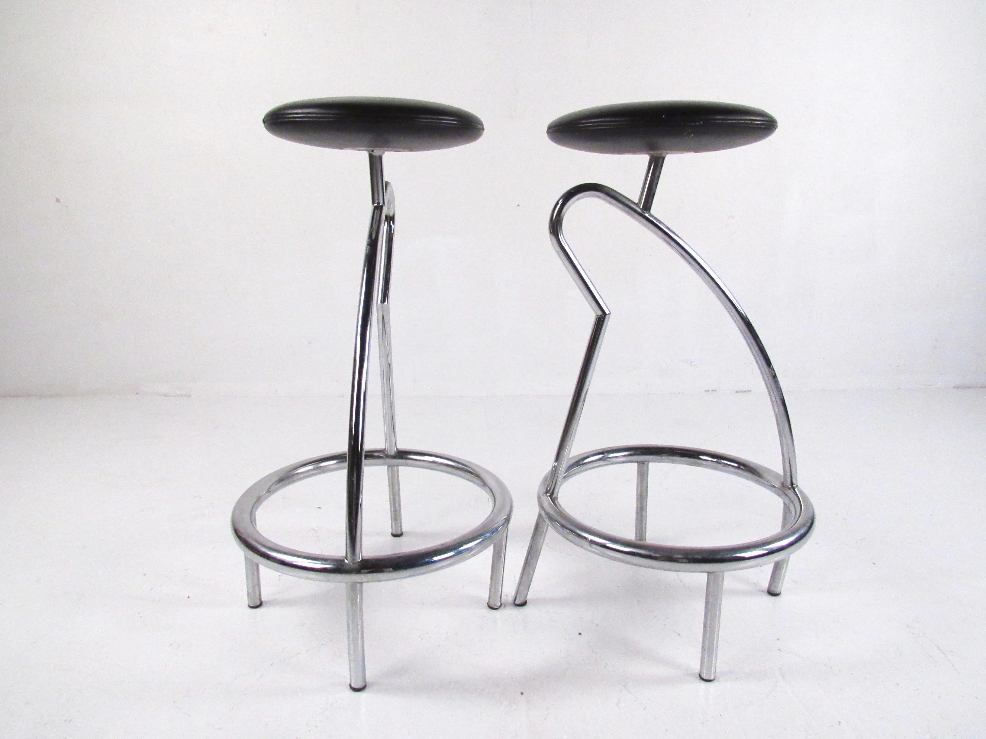 This shapely pair of modern chrome bar stools feature bent metal bases with comfortably padded leather seats. The unique design of the bent metal bases add simple yet impressive Italian modern feel to bar or tall counter seating. Seat height is 31