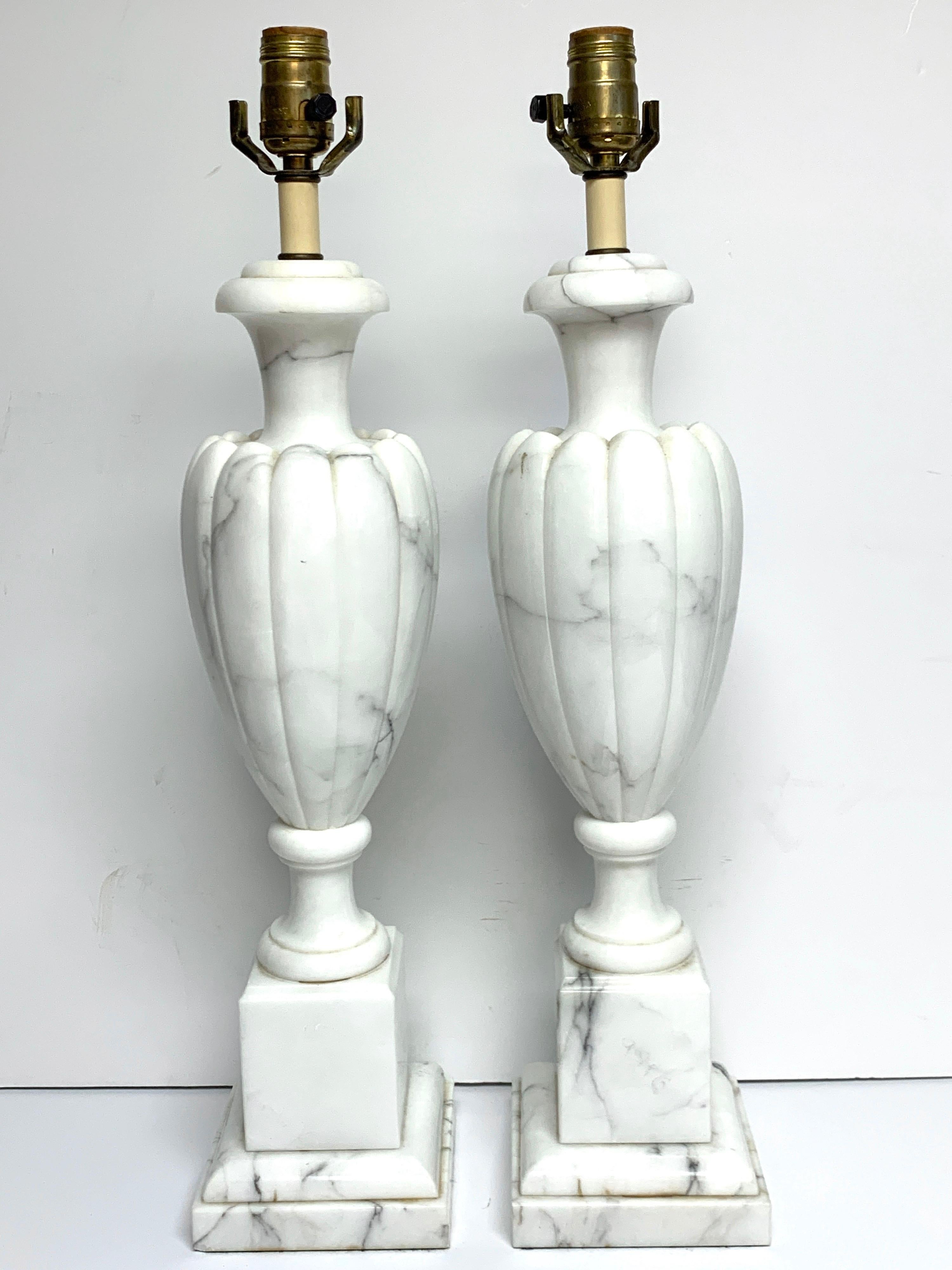 Pair of Italian modern Carrera marble lamps, each one of carved Mellon body raised on 5-inch square pedestal bases. The lamps are 24