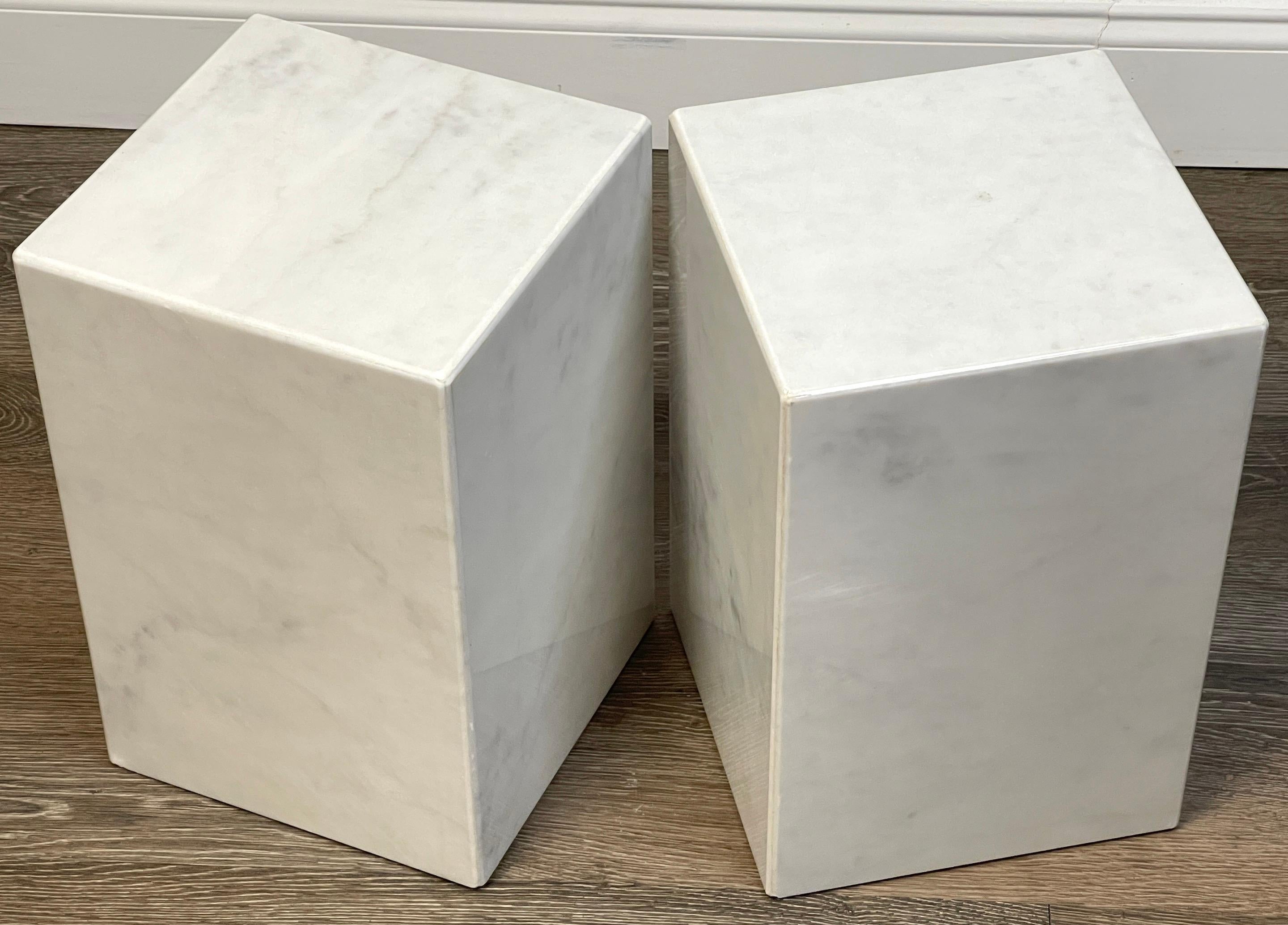 Pair of Italian Modern Carrera Marble Monolith side tables
 Each one with book-matched Carrera marble joined with seamless polished edges. Hollow construction. 
Each table stands 15-Inches high with a 10-Inch square diameter.