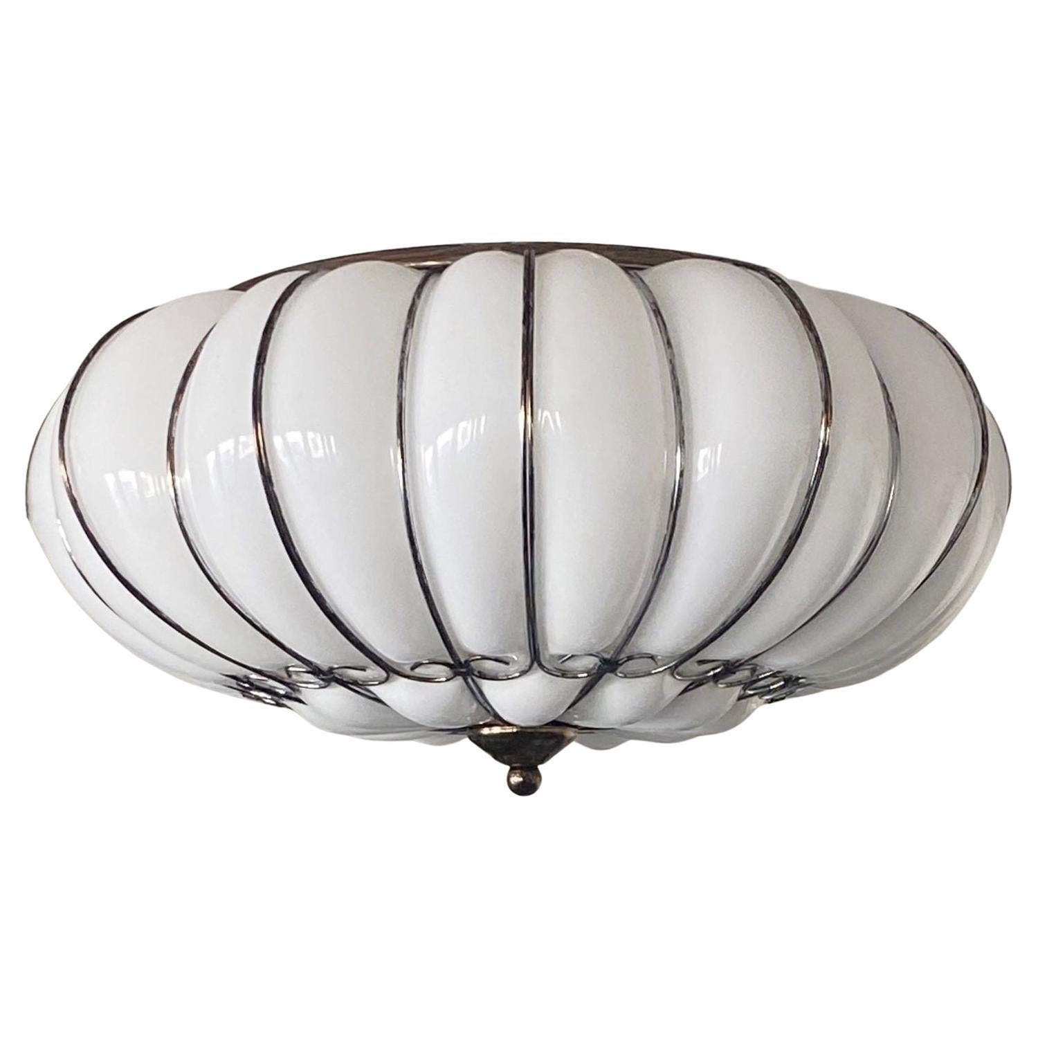A pair of Modern Classic Venetian Murano glass four-light ceiling lights, Italy, early 21st-century. Hand-blown Murano milk gass beautifuly caged in patinated metal frame. Both pieces in excellent condition, rewired to medern standards. Each flush