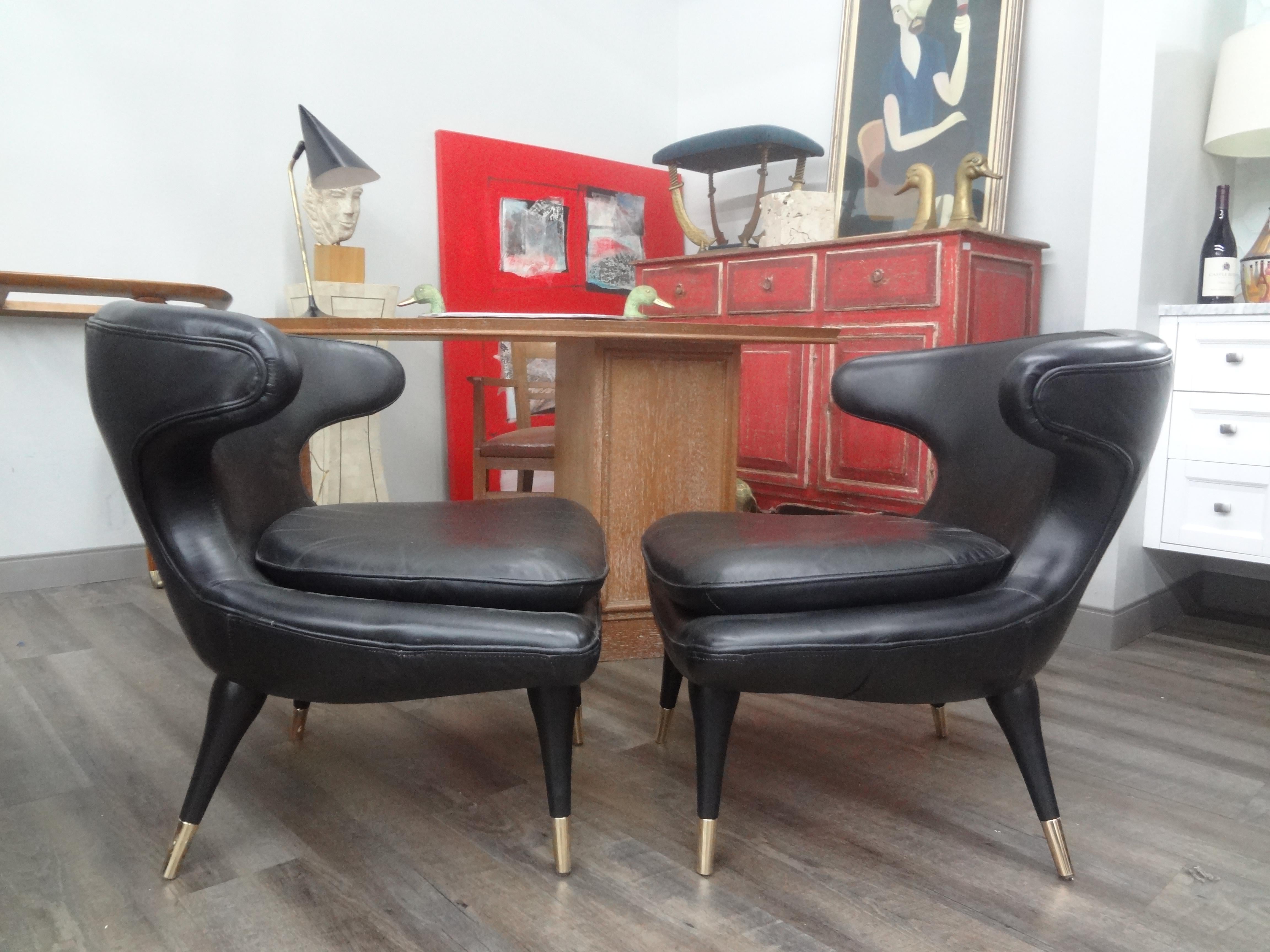 Pair of Italian Modern curved back chairs upholstered in black leather.
These unique sculptural Italian lounge chairs have beautifully tapered legs with brass sabots. They are upholstered in black leather and are extremely comfortable.
The curved