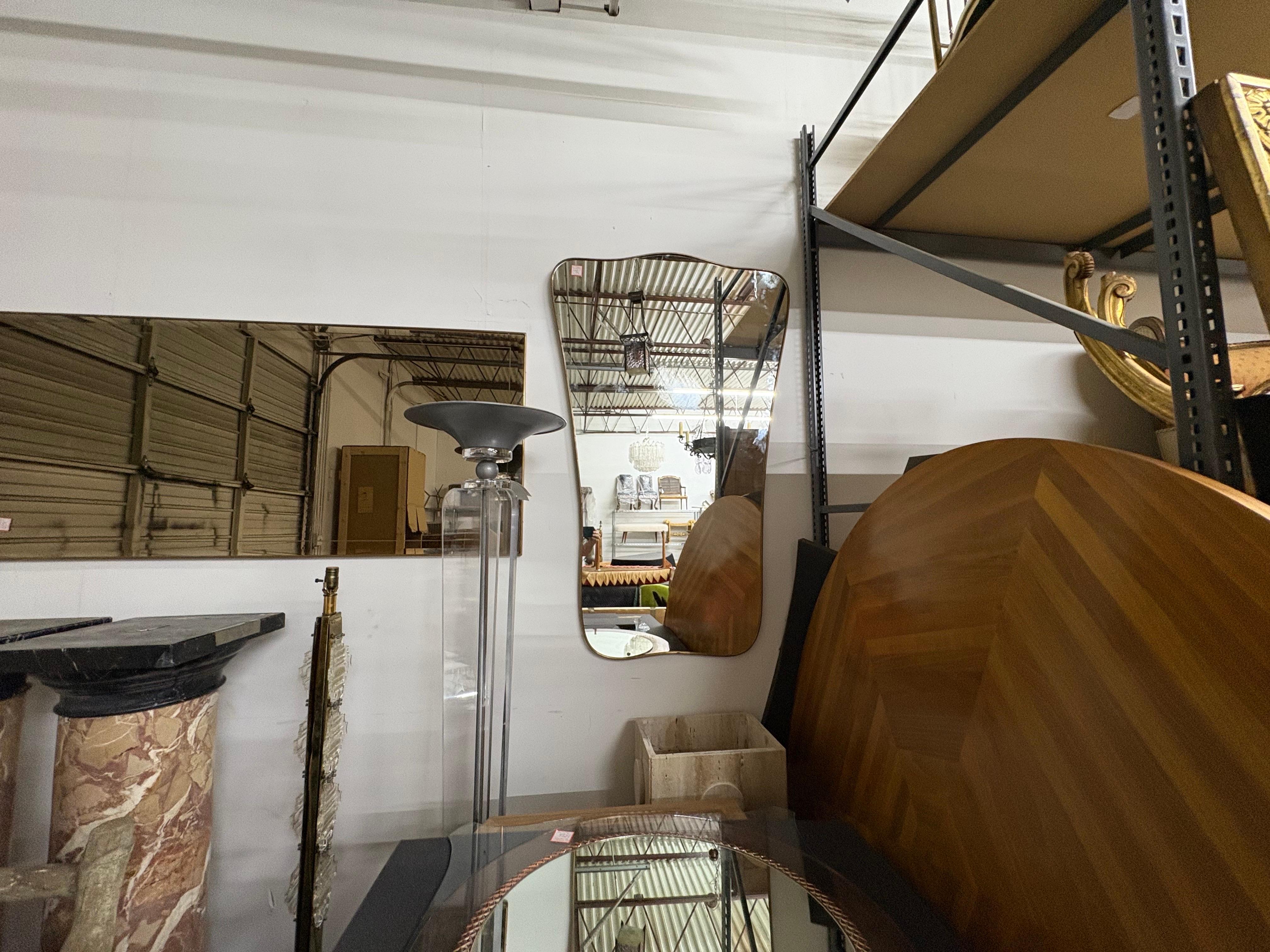 Pareja de espejos italianos modernos de latón inspirados en Gio Ponti.
Se ofrece un elegante par de espejos italianos de latón modernos de mediados de siglo.
Estos espejos, que recuerdan la obra de Gio Ponti, son una pareja exacta y quedarían muy