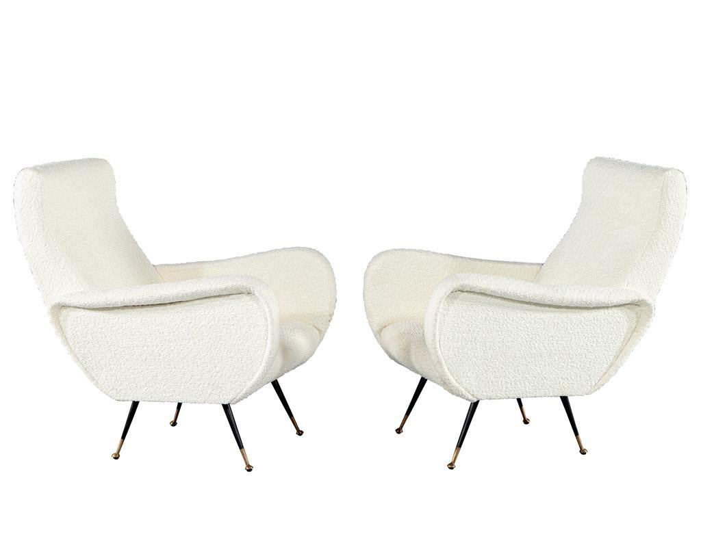 These Modern Lounge Chairs are a stunning design from the 1970's, made in Italy. The beautiful textured off white fabric is soft to the touch, and the sleek black metal legs are finished with brass foot caps for added sophistication. The unique