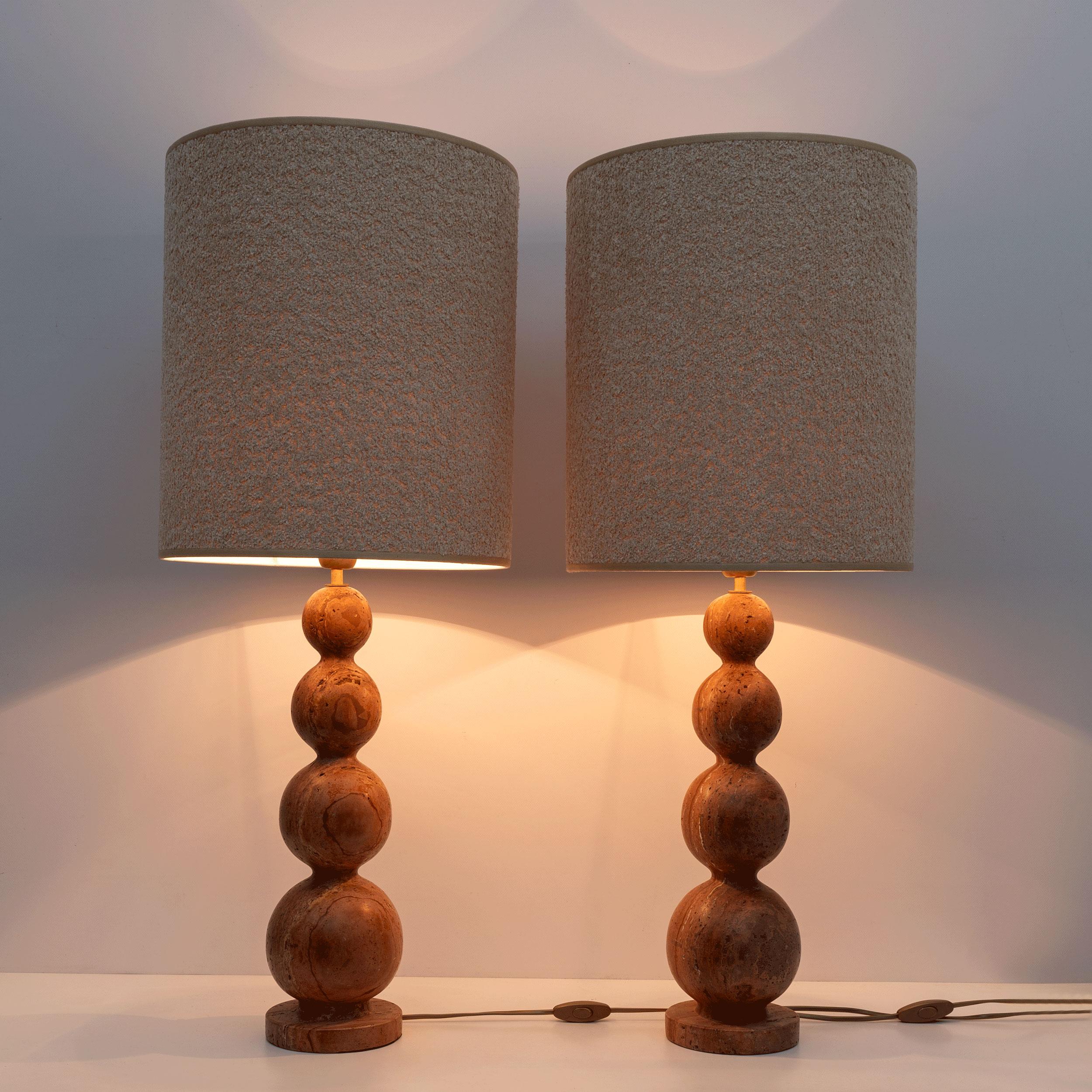 Pair of mid-century modern style lamps, made in Italy from a single block of red travertine, with spherical workmanship. 
Each lamp measures without lampshade height cm 54 x Diameter cm 14