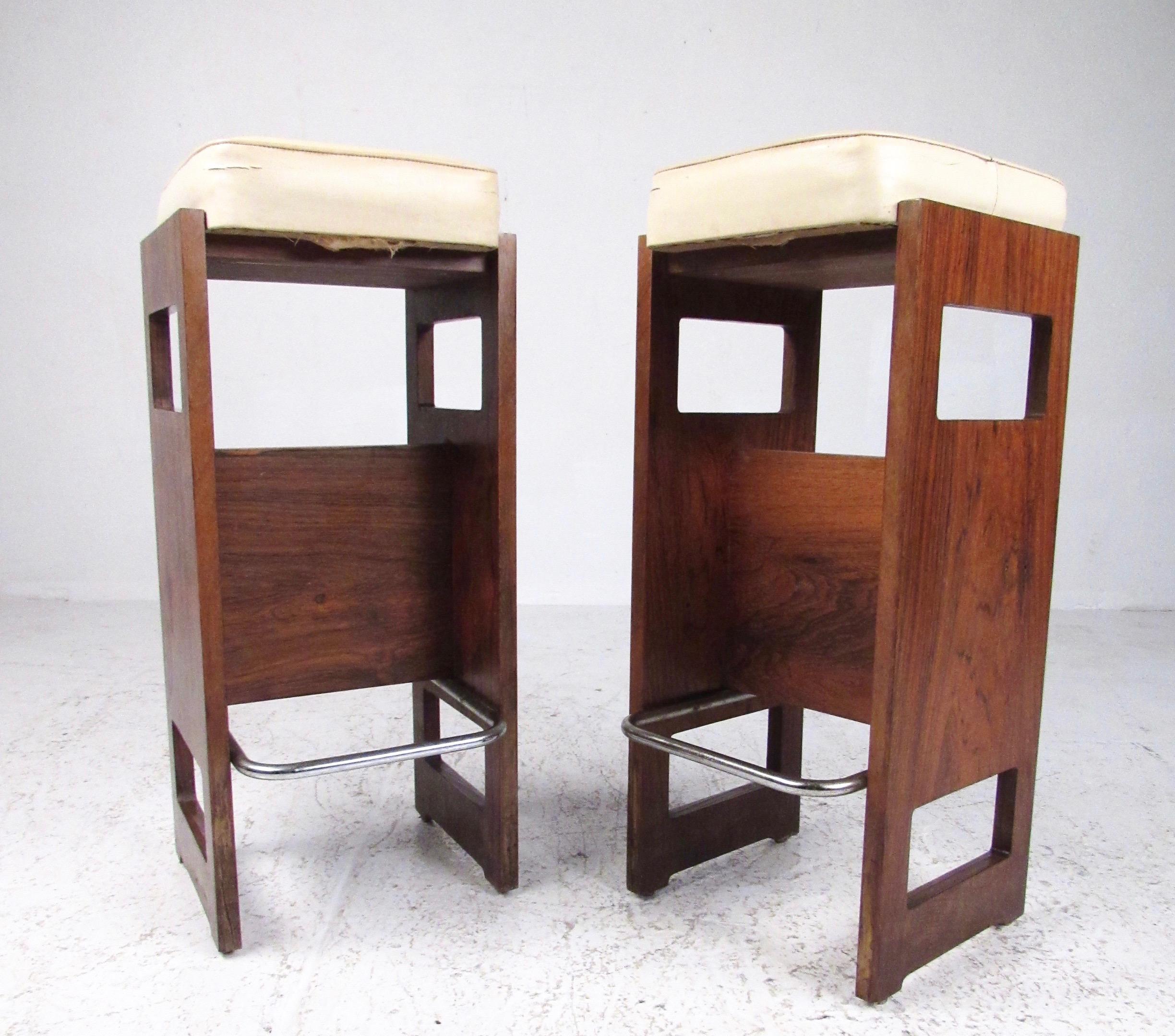 Stylish pair of vintage modern stools feature vinyl seats and sculptural rosewood bases. The midcentury Italian pair stands a versatile 28 inches tall, for a striking addition to home or business counter or bar seating. Please confirm item location