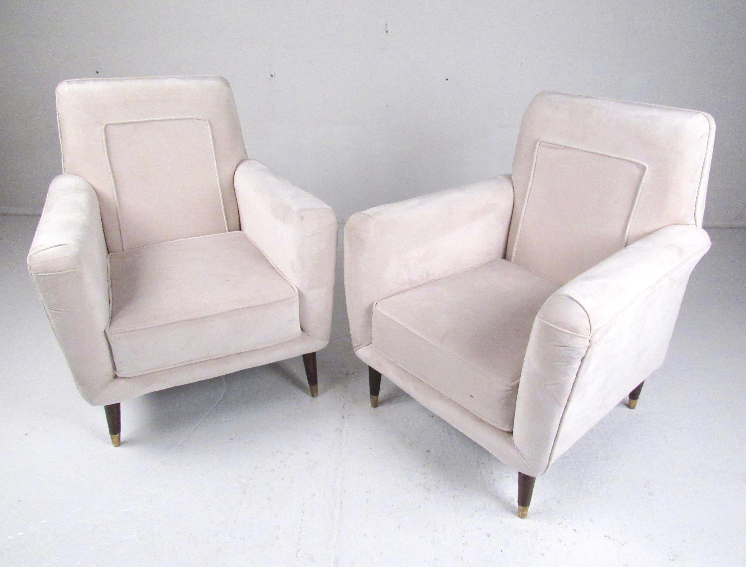 Stylish pair of vintage modern armchairs feature shapely upholstered seats/backs paired with tapered walnut legs complete with brass sabot feet. Simple mid-century modern style lounge chairs make a comfortable pair of lounge chairs for home or